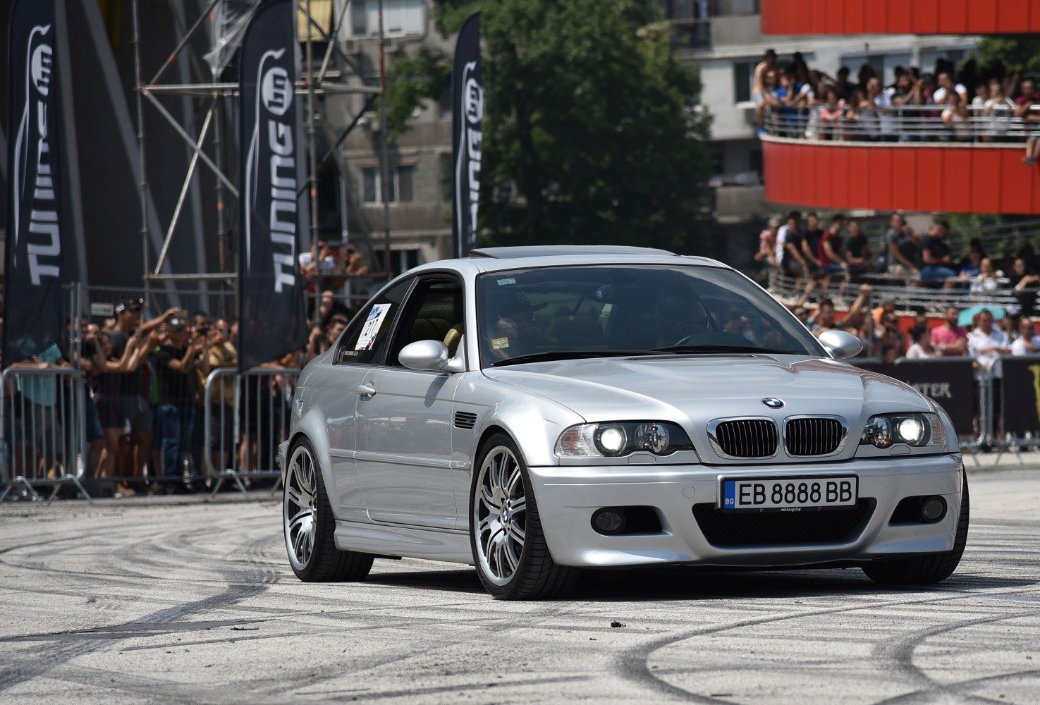Silver coupe with aggressive front and alloy wheels in motion