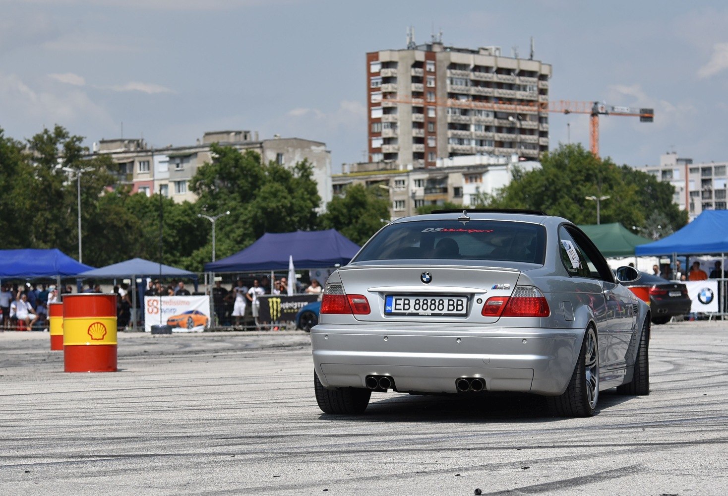 Rear view of silver coupe with quad exhaust and wide tires