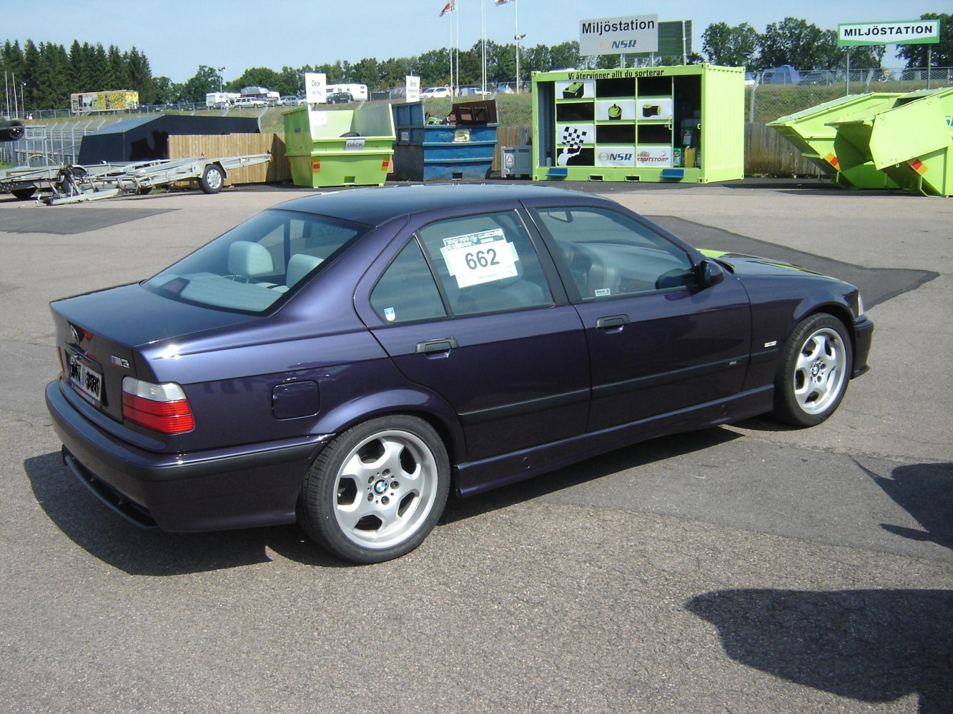 Side profile of a classic 1990s sporty sedan with alloy wheels