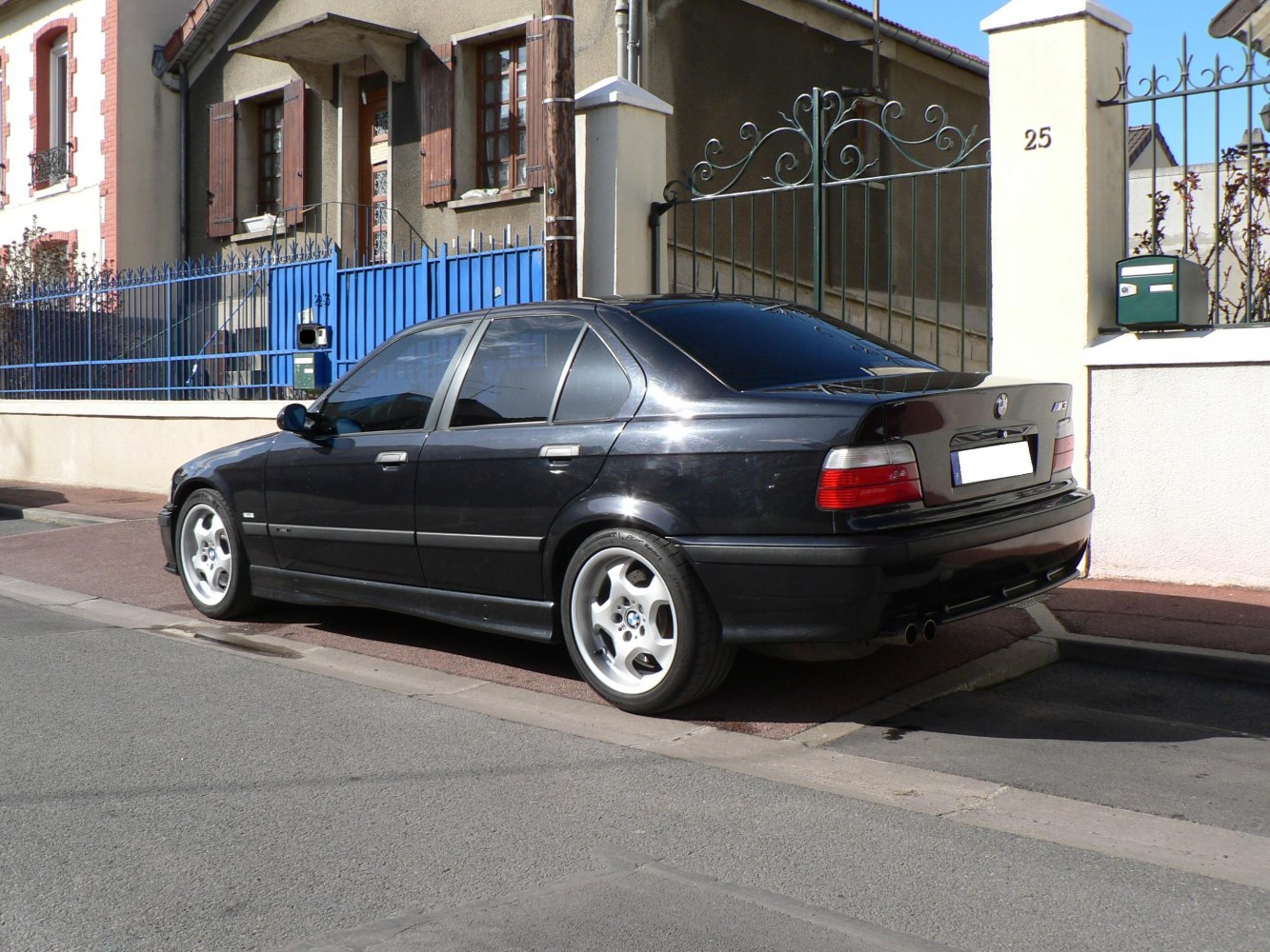 Rear side view of a black sporty sedan with alloy wheels