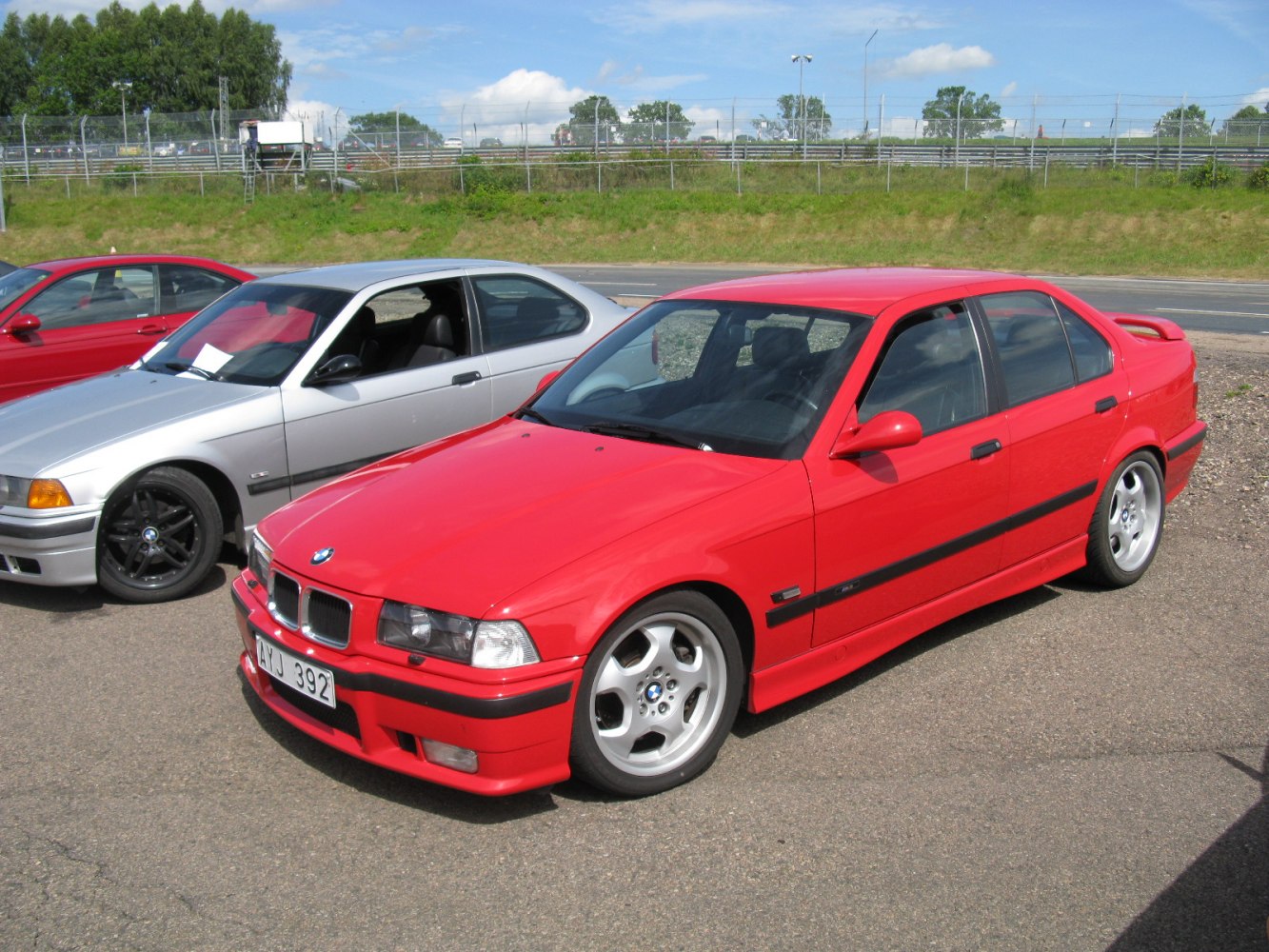 Red sporty sedan with alloy wheels in front-side view