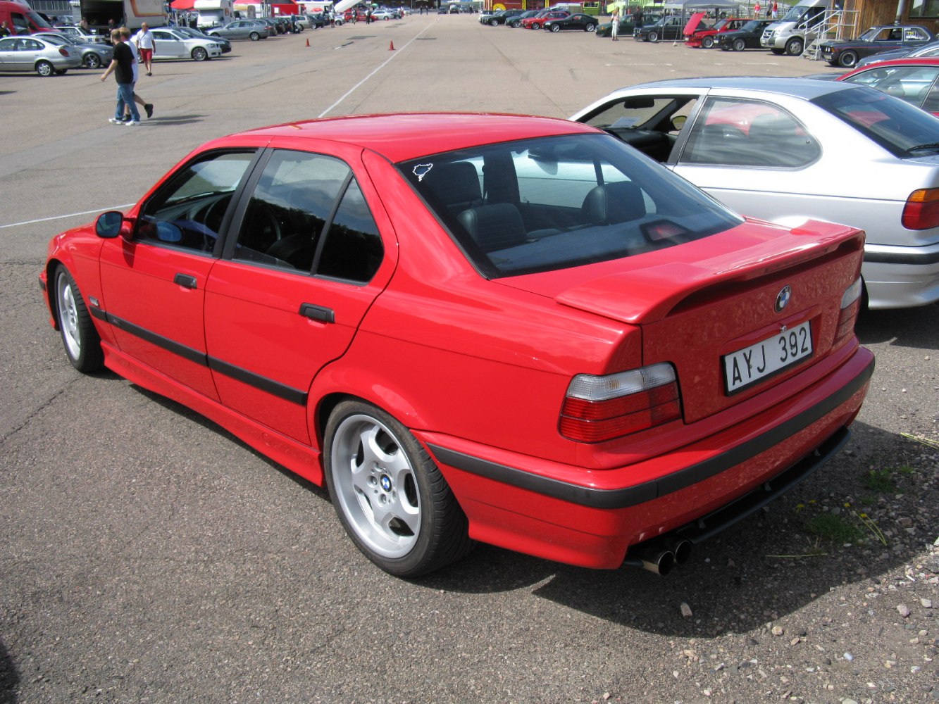 Rear view of red sedan with spoiler and alloy wheels