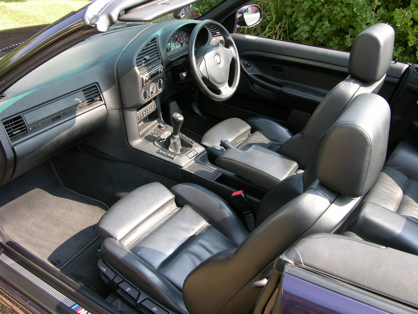 Convertible car interior with leather seats and manual transmission