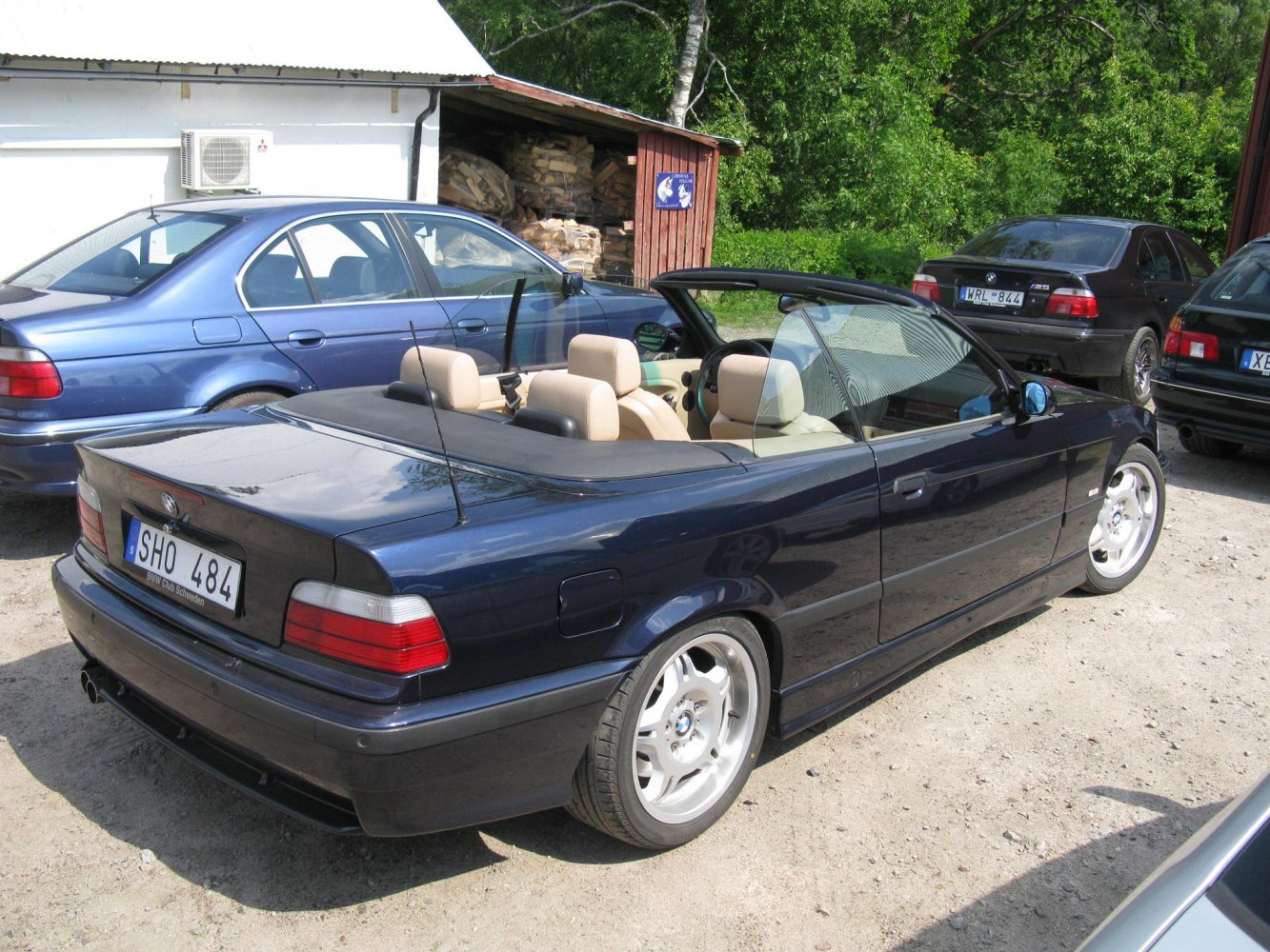 Rear side view of convertible car with roof down and beige interior