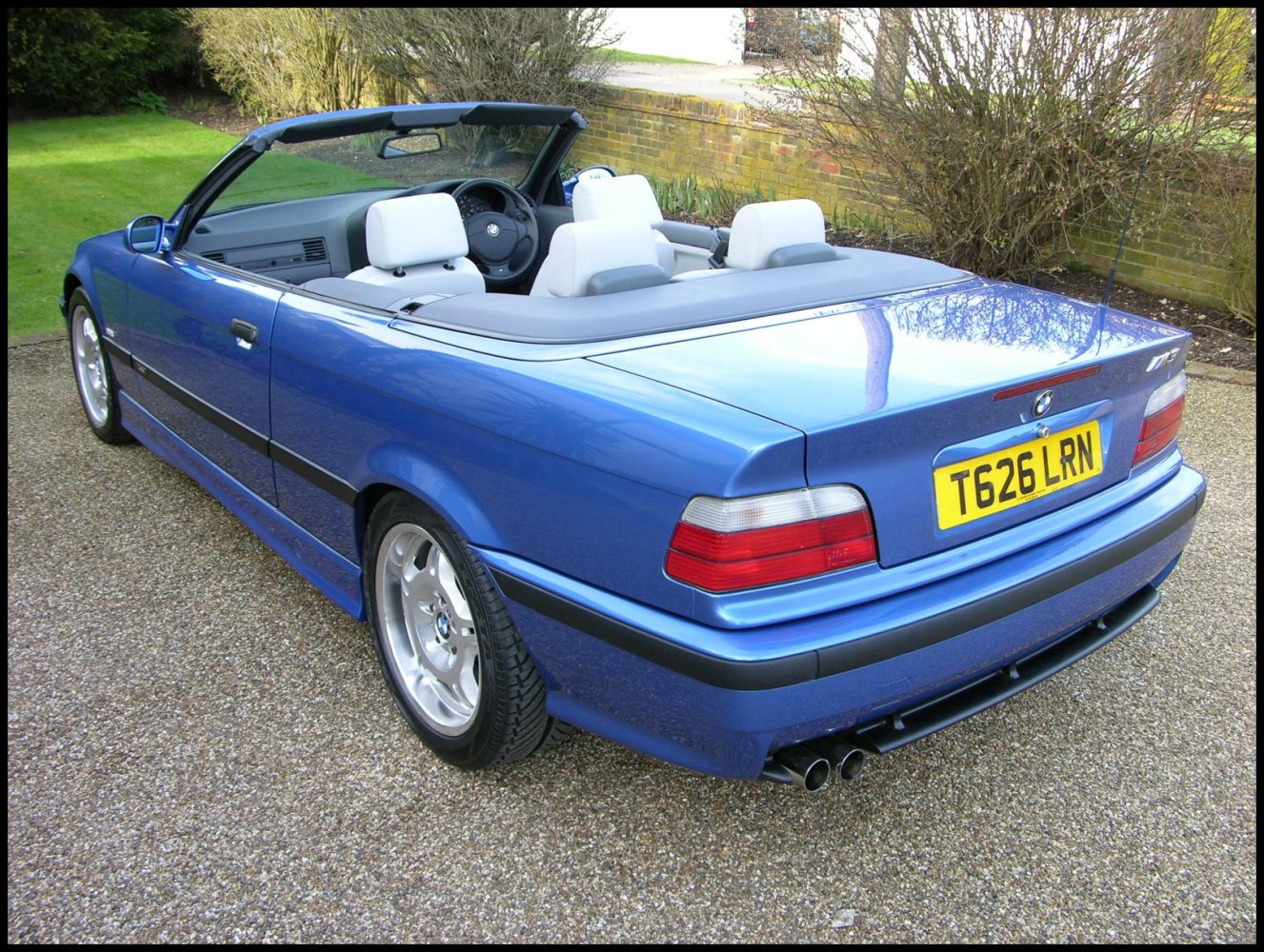 Rear and side view of blue convertible with open roof