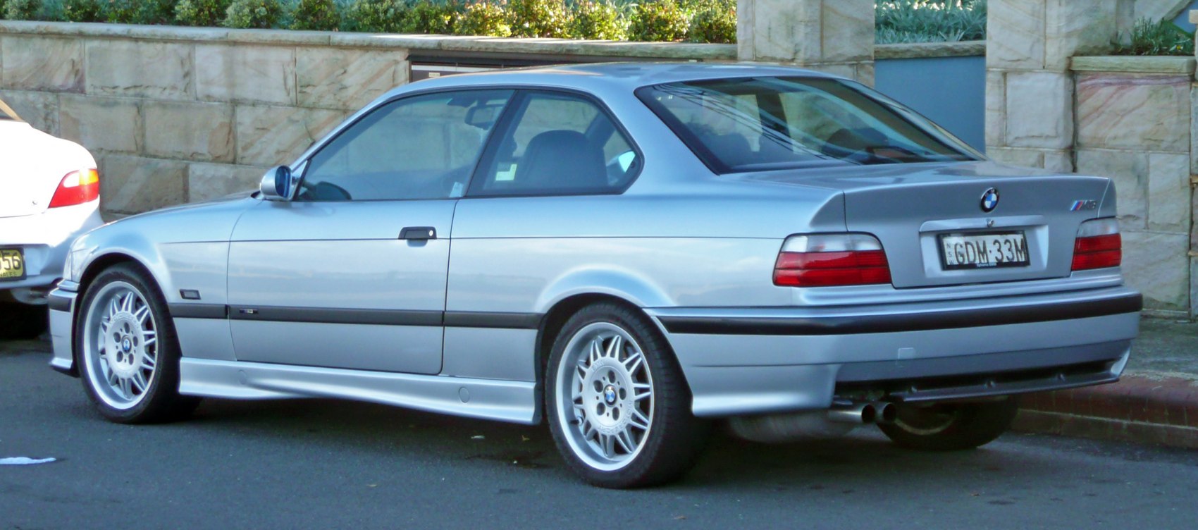 Rear side view of a sporty coupe with distinctive alloy wheels.