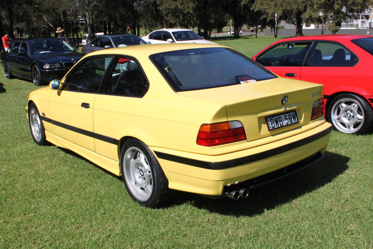 Yellow BMW M3 coupe rear side with spoiler and dual exhaust