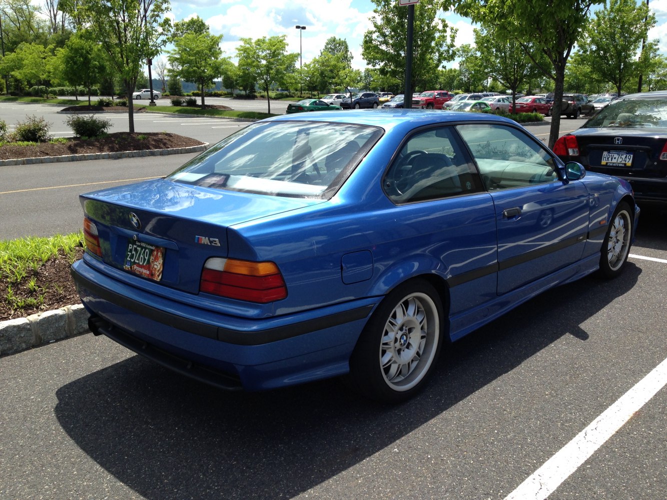 Rear side view of blue sporty coupe with classic taillights