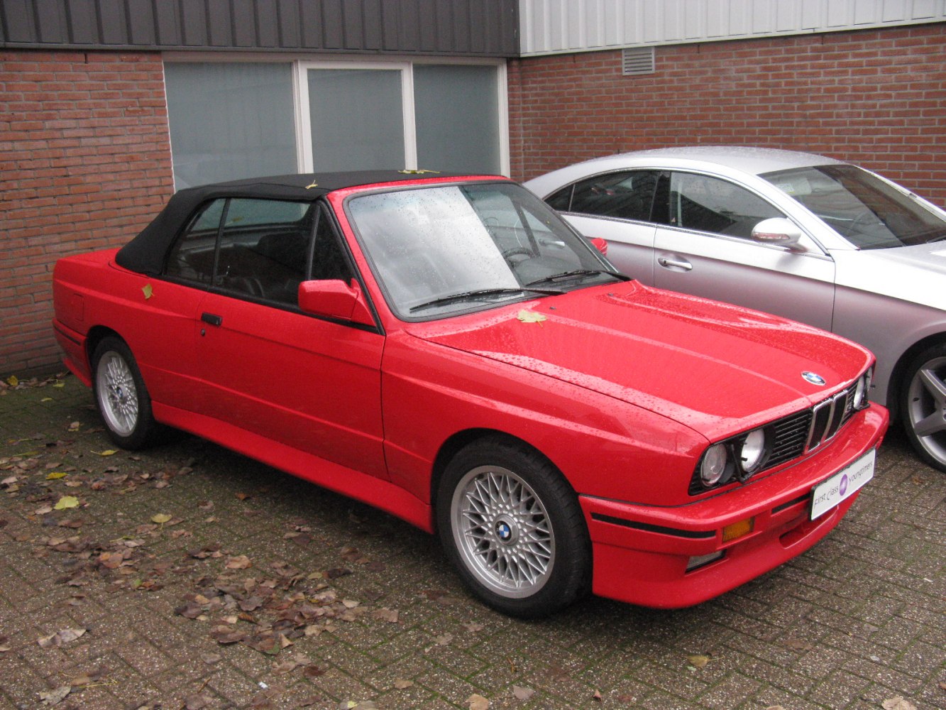 Red convertible with black soft top and mesh alloy wheels