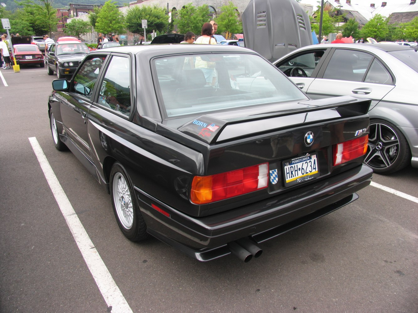 Rear view of a black coupe with rear spoiler and dual exhaust pipes