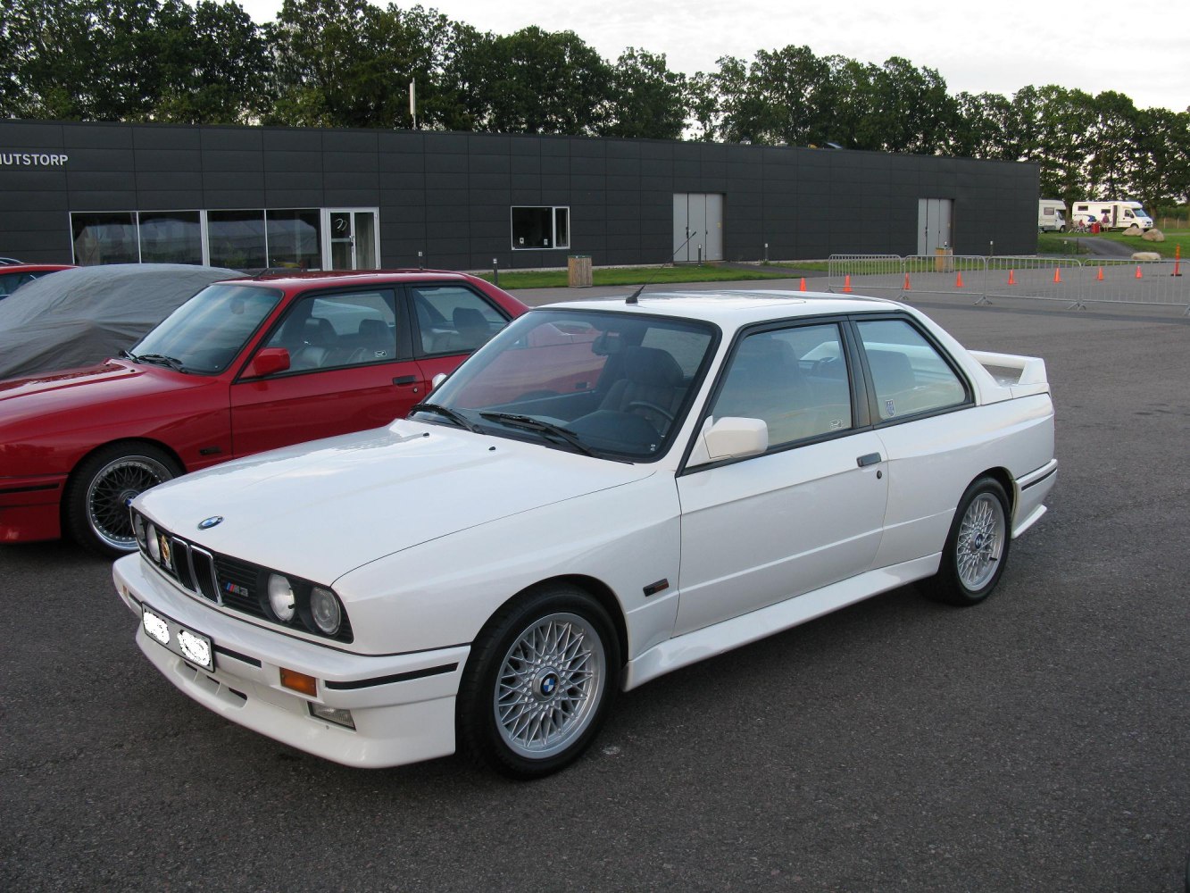 White coupe with rear spoiler and mesh alloy wheels