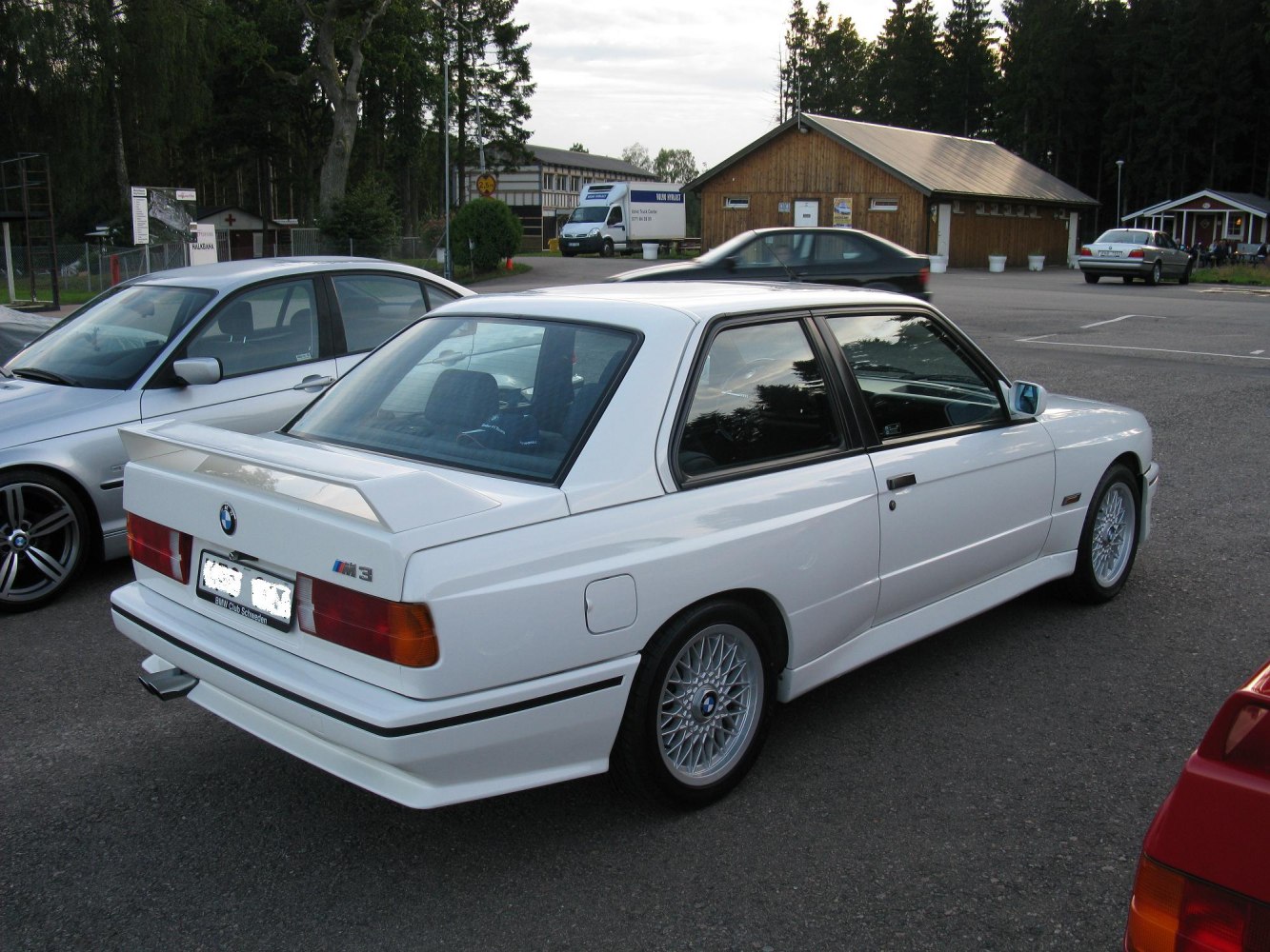 White coupe with rear spoiler and multi-spoke wheels