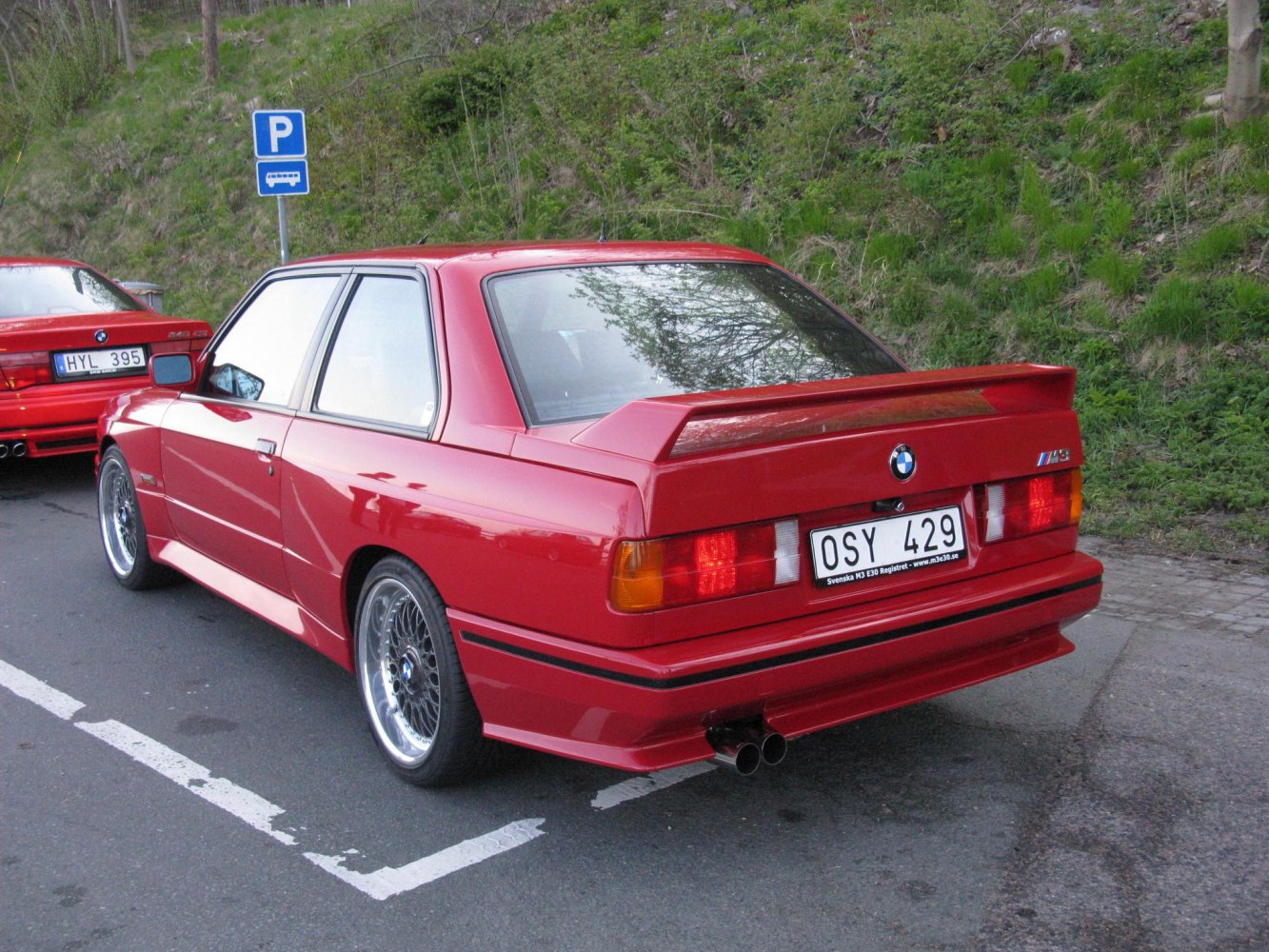 Red coupe rear view with spoiler and alloy wheels
