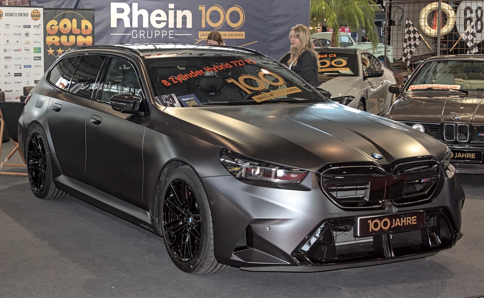 Matte black modern station wagon with black multi-spoke wheels and aggressive front air intakes