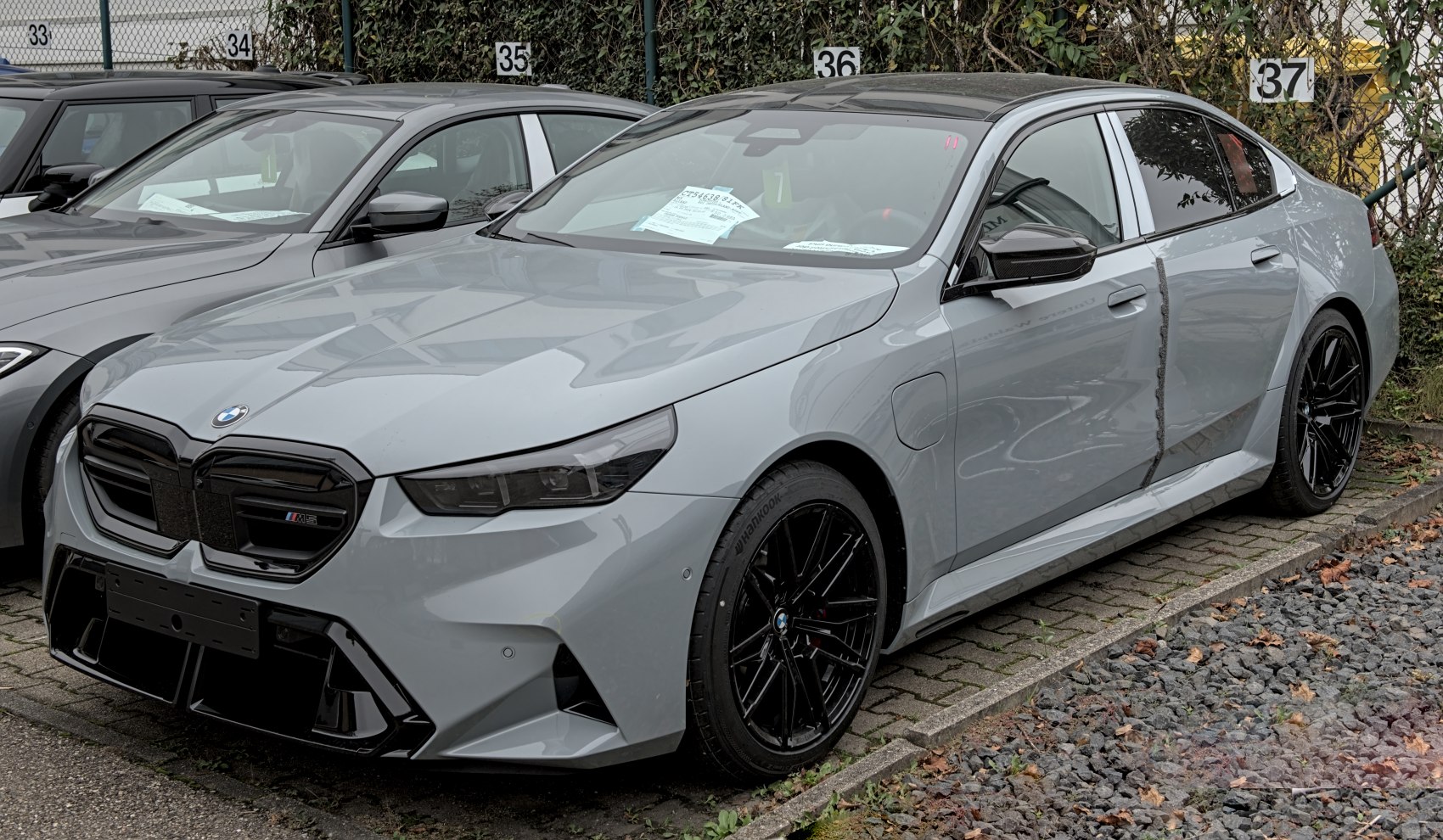 Grey sedan with aggressive front and black multi-spoke wheels