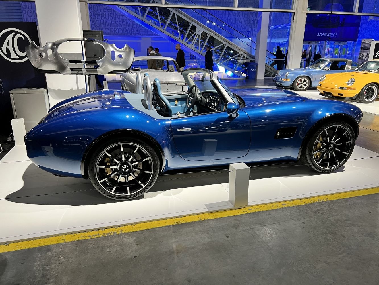 Open-top blue roadster with sporty alloy wheels and minimal interior.