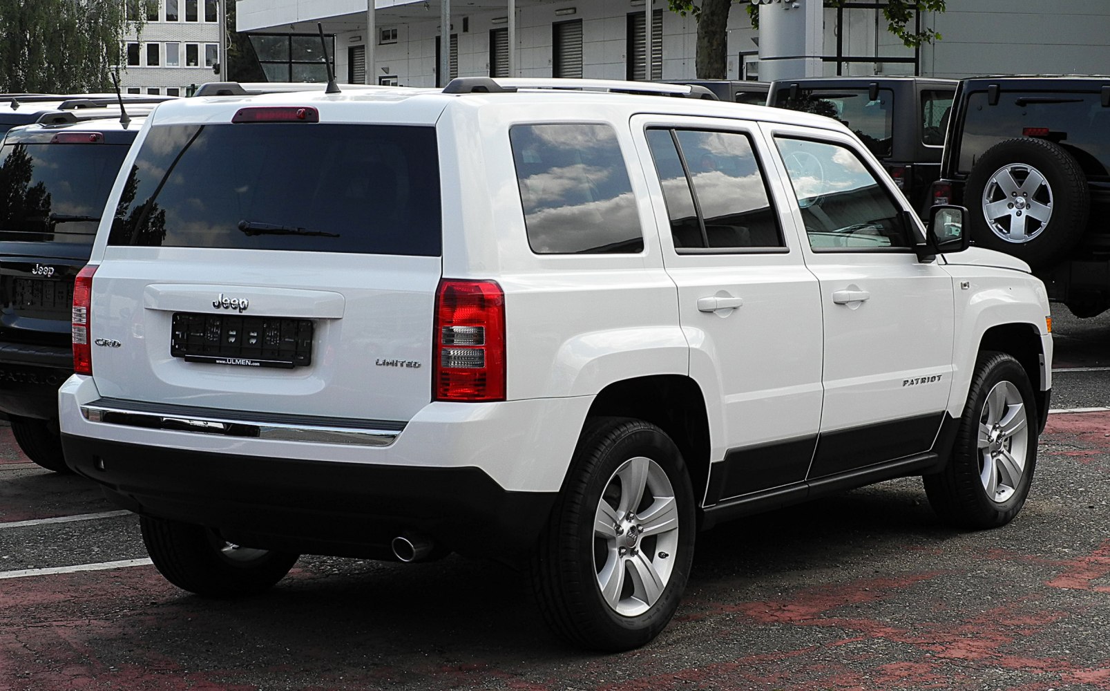 Rear and side view of white SUV with tinted windows and 5-spoke alloy wheels