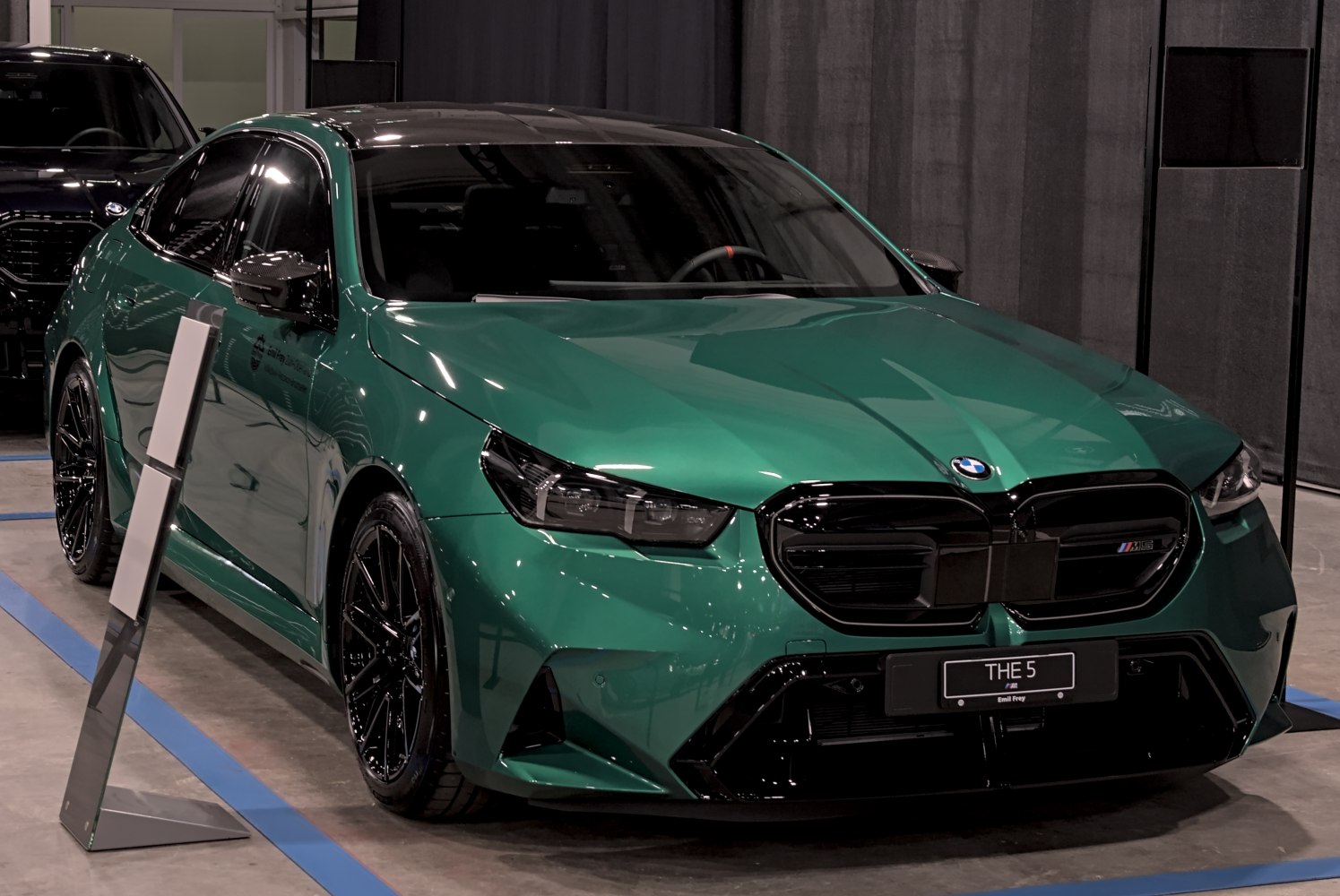 Sporty green sedan with aggressive front grille and black alloy wheels