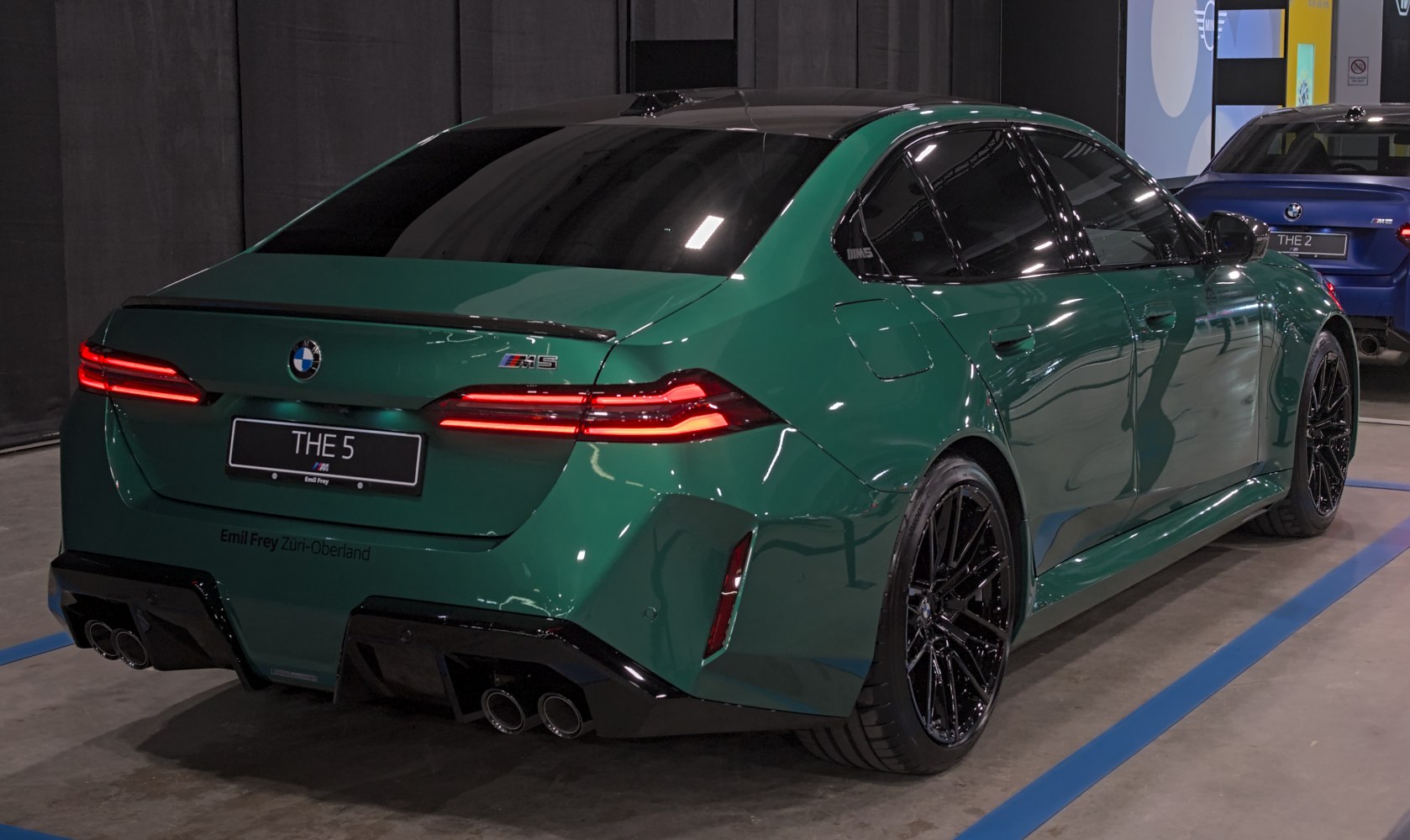 Rear view with LED taillights, quad exhaust pipes, rear spoiler, and green paint