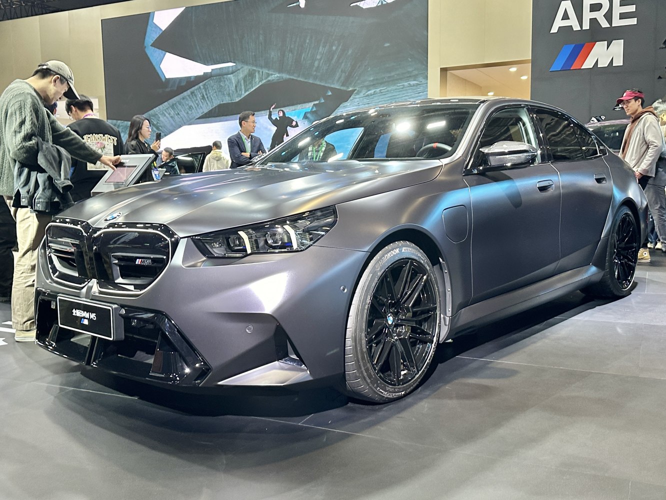 Matte gray luxury sedan with black wheels and aggressive front design