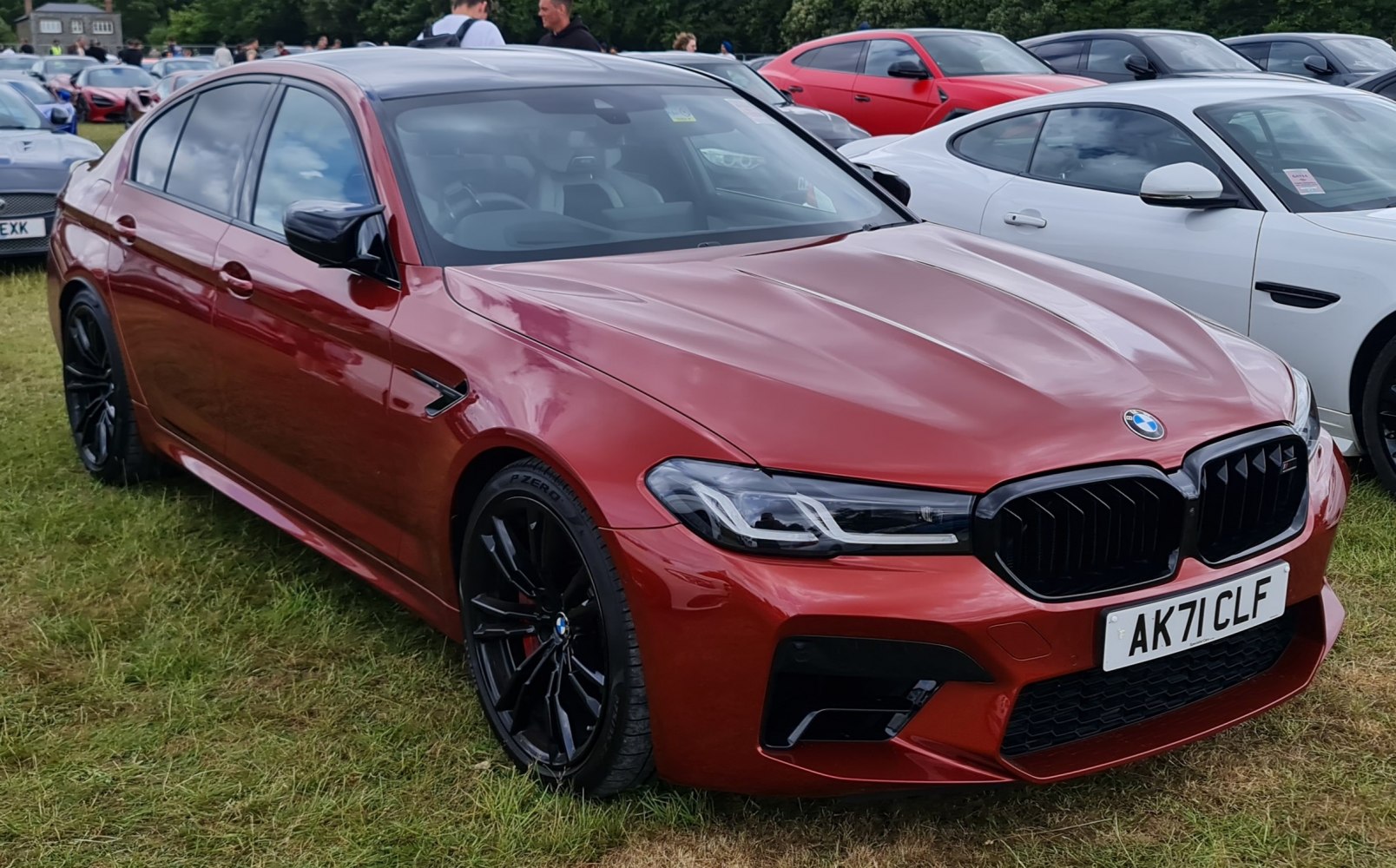 Metallic red sports sedan with black kidney grille and black multi-spoke alloy wheels