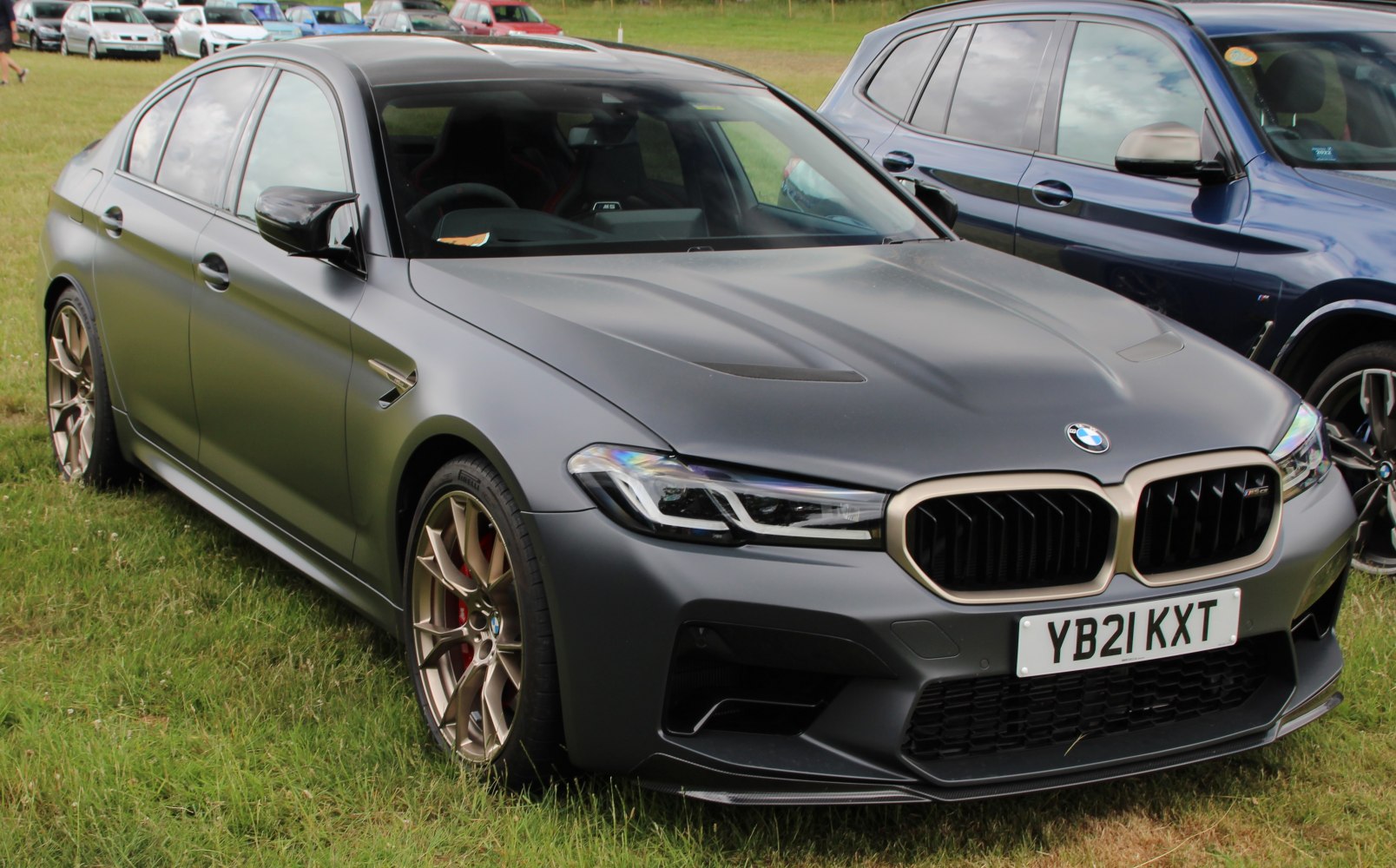 Matte gray sedan with bronze alloy wheels and aggressive front grille