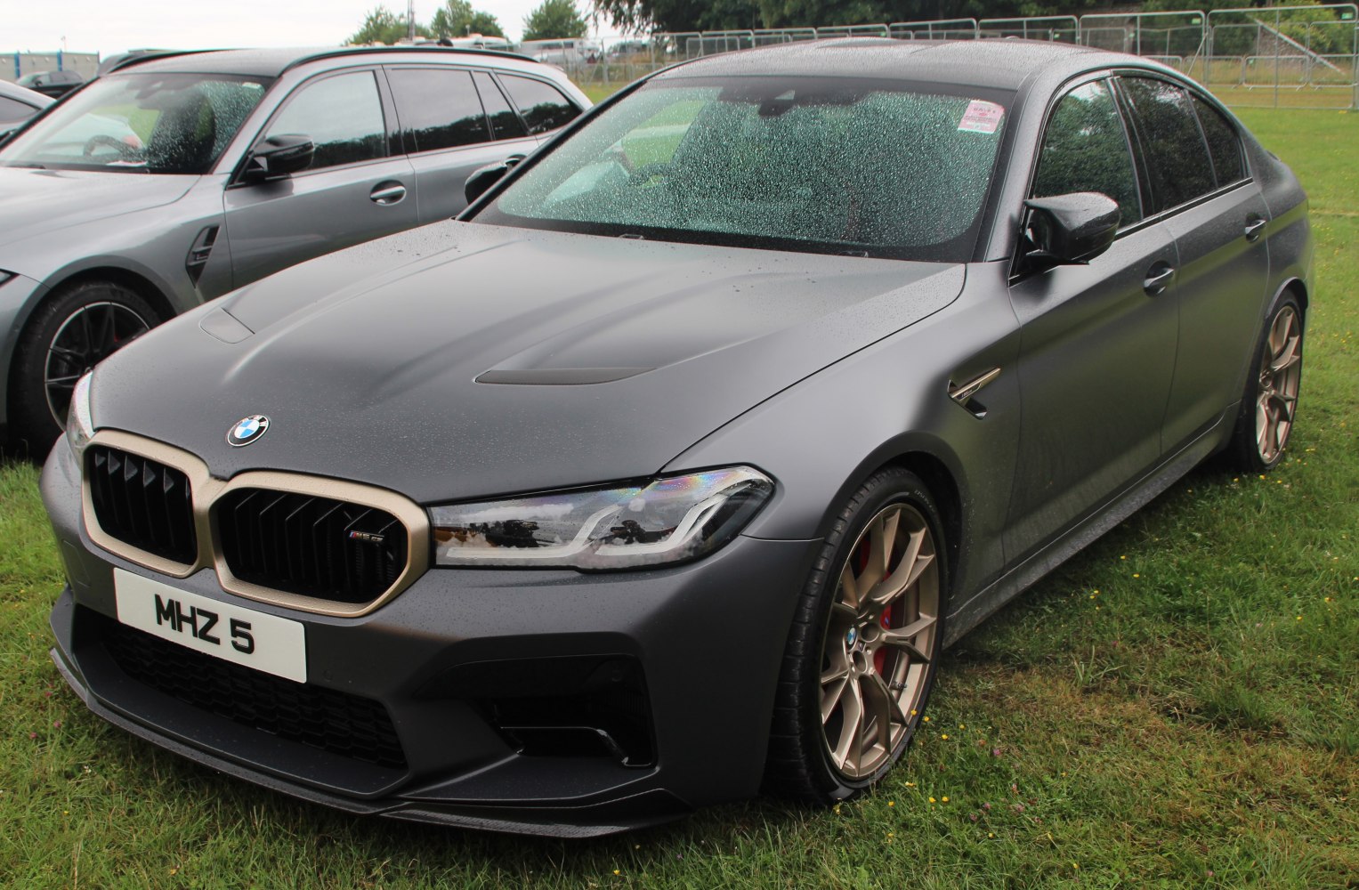 Matte gray performance sedan with bronze wheels and aggressive front design