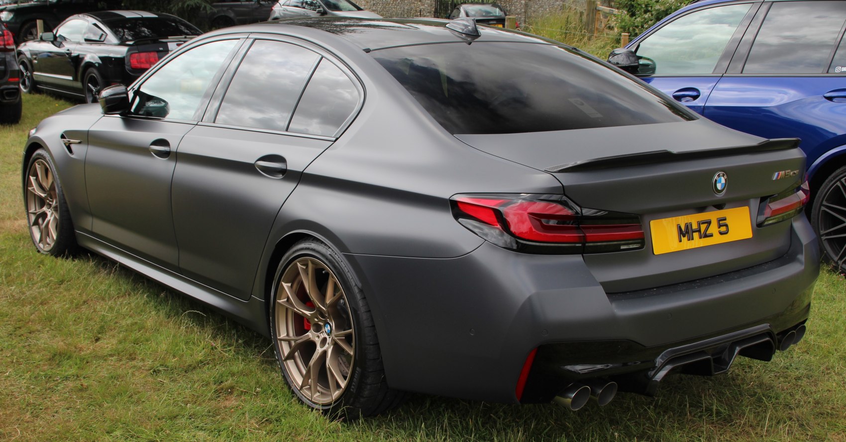 Matte finished sports sedan rear with alloy wheels and quad exhausts