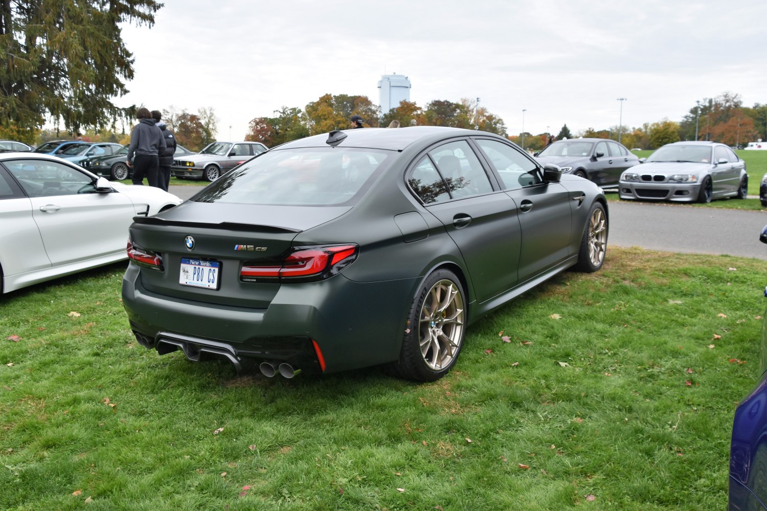 Rear view of matte finish sedan with quad exhaust and bronze wheels
