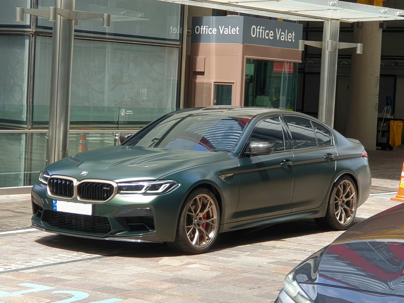 Matte green luxury sedan with aggressive front and sporty wheels