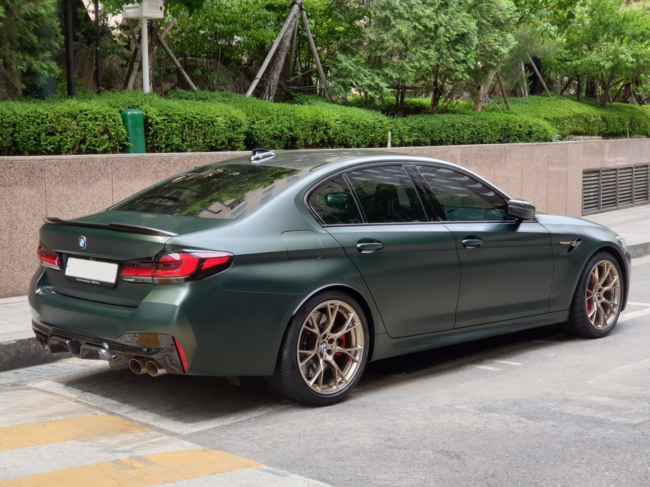 Matte green high-performance sedan with quad exhausts and sport alloy wheels