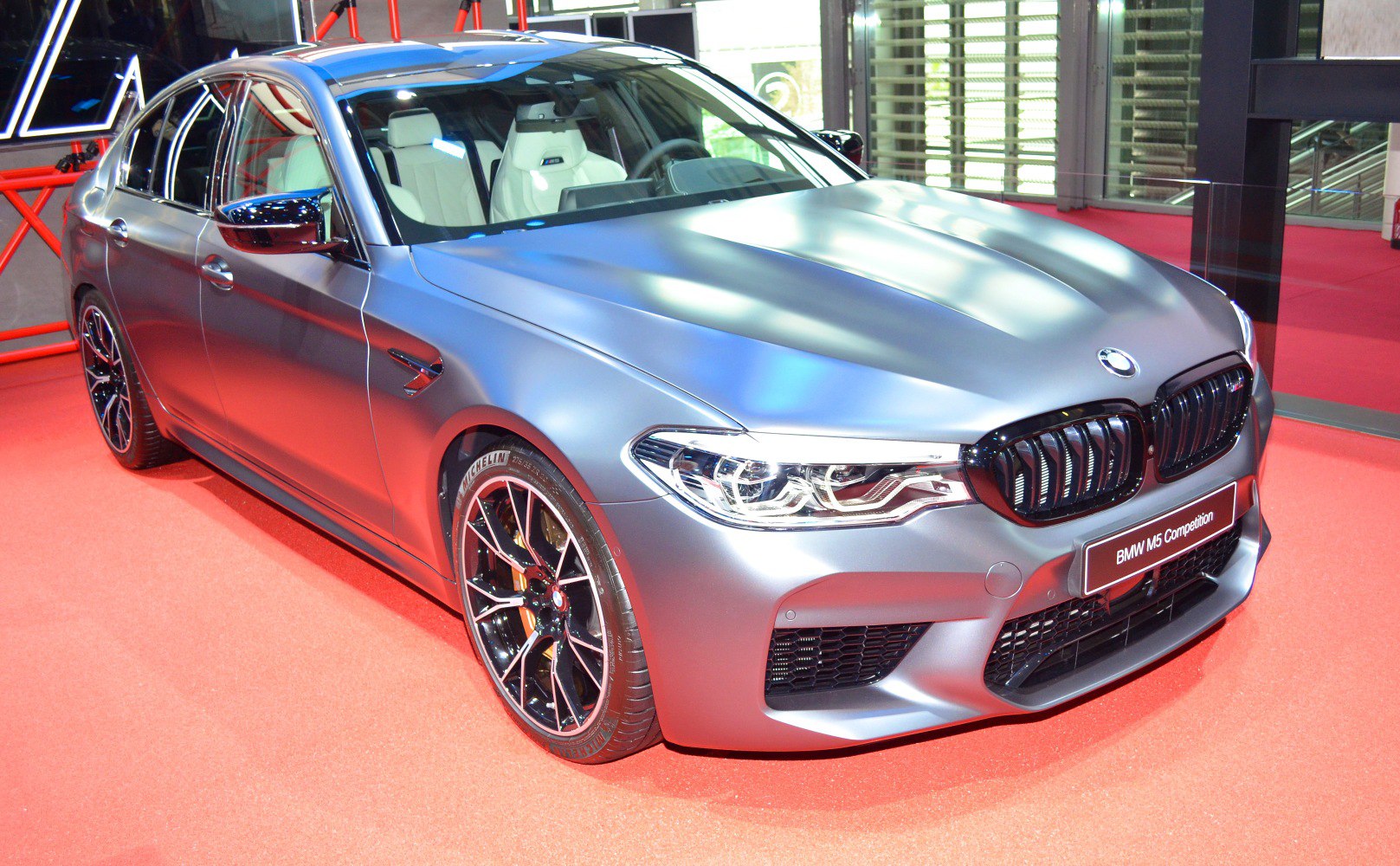 Sporty sedan front and side view with aggressive grille and black alloy wheels