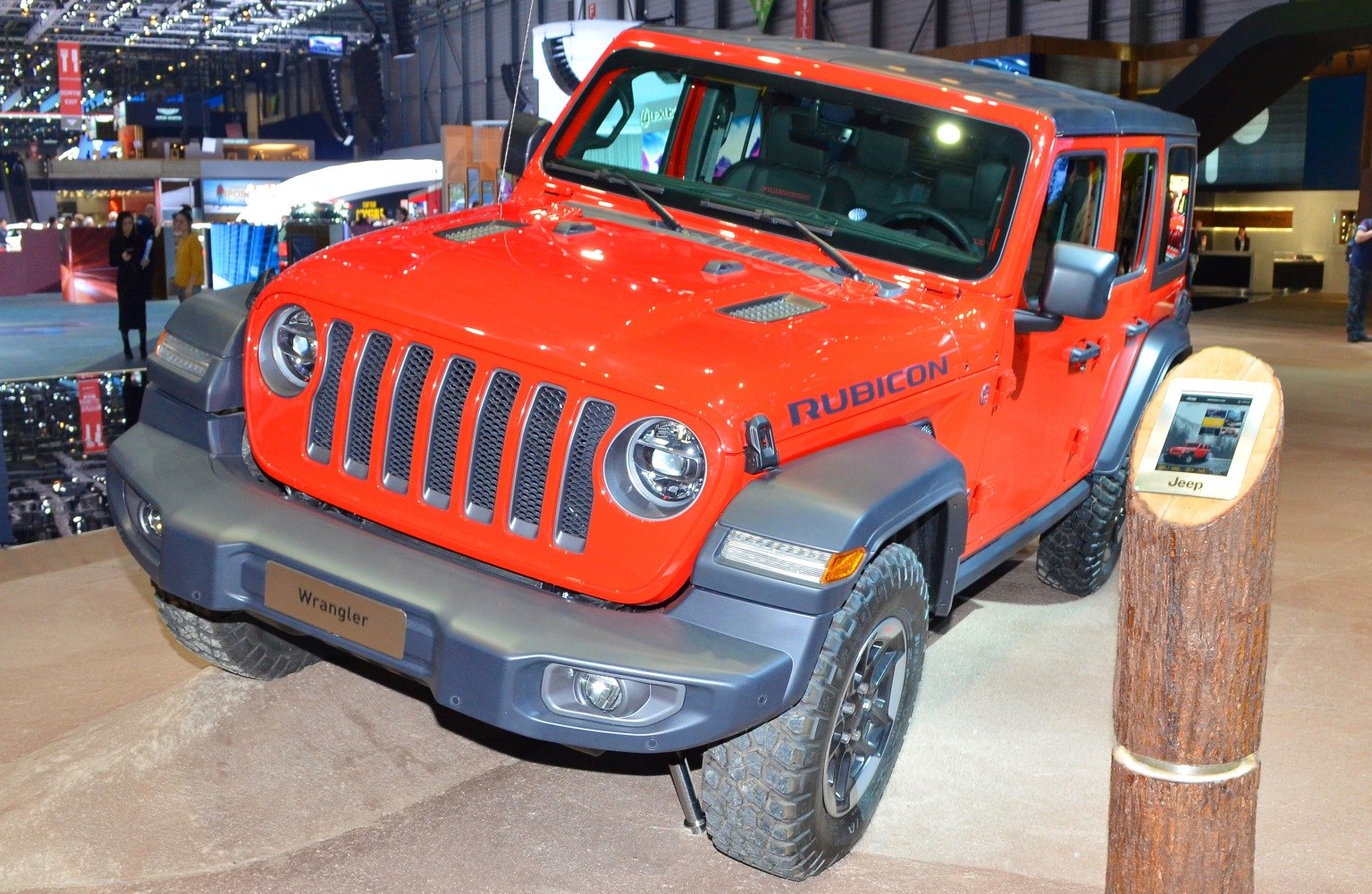 Rugged front grille, round headlights, off-road tires, four-door SUV