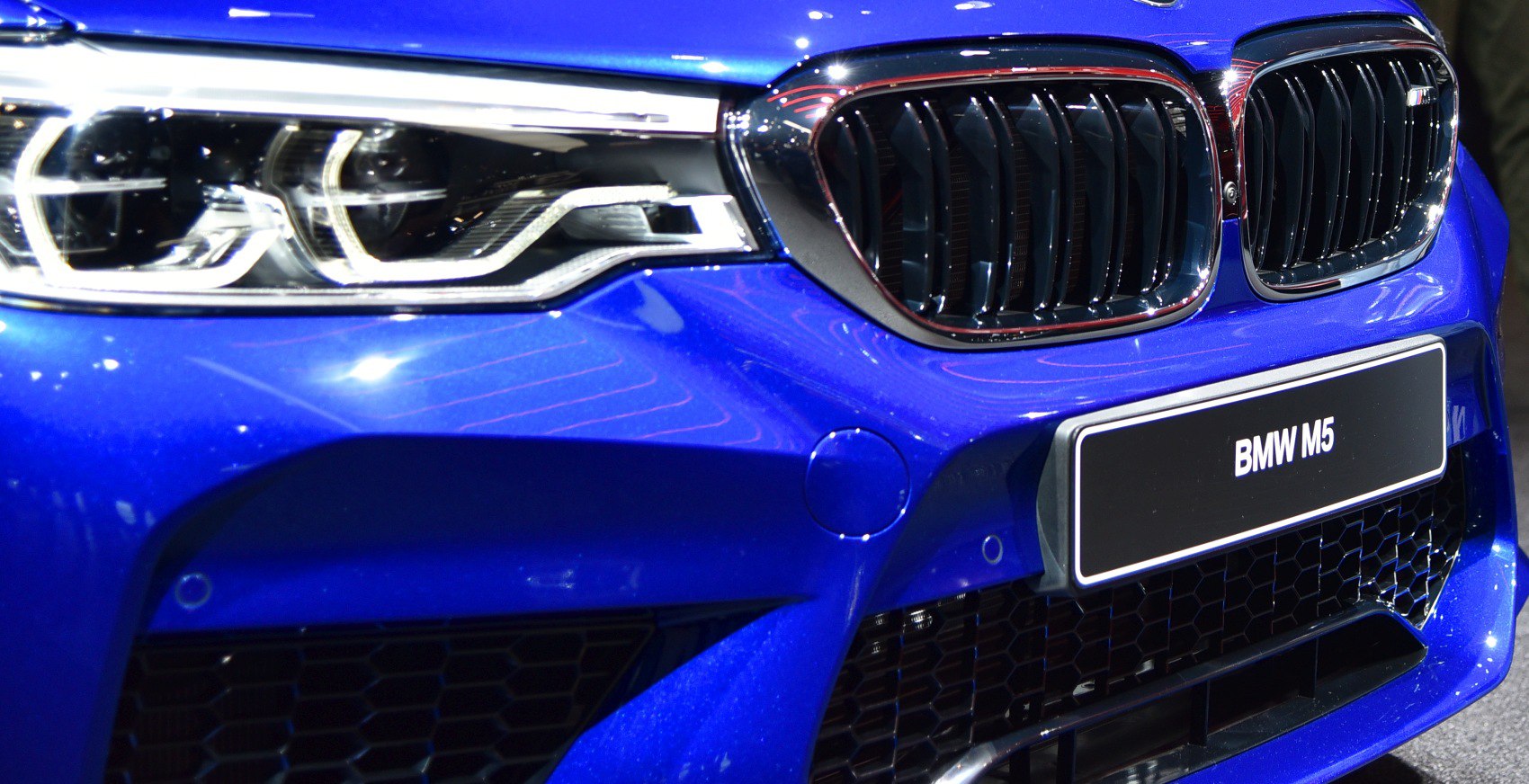 Close-up of front kidney grille and headlight in blue paint