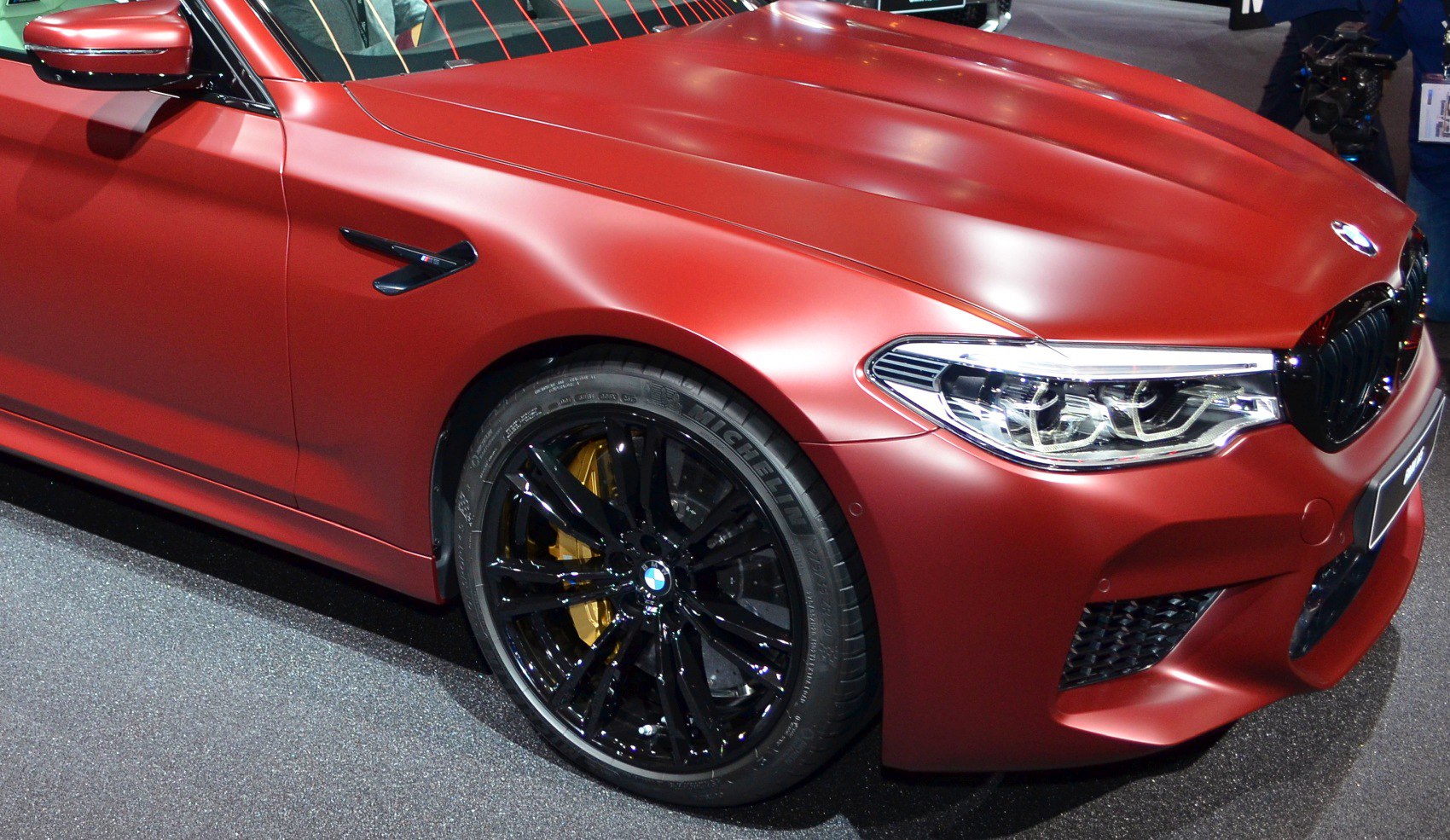 Front side view with black alloy wheels and red matte paint