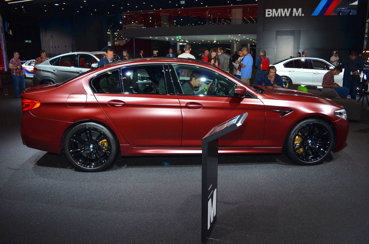 Red luxury sedan with black wheels and yellow brake calipers