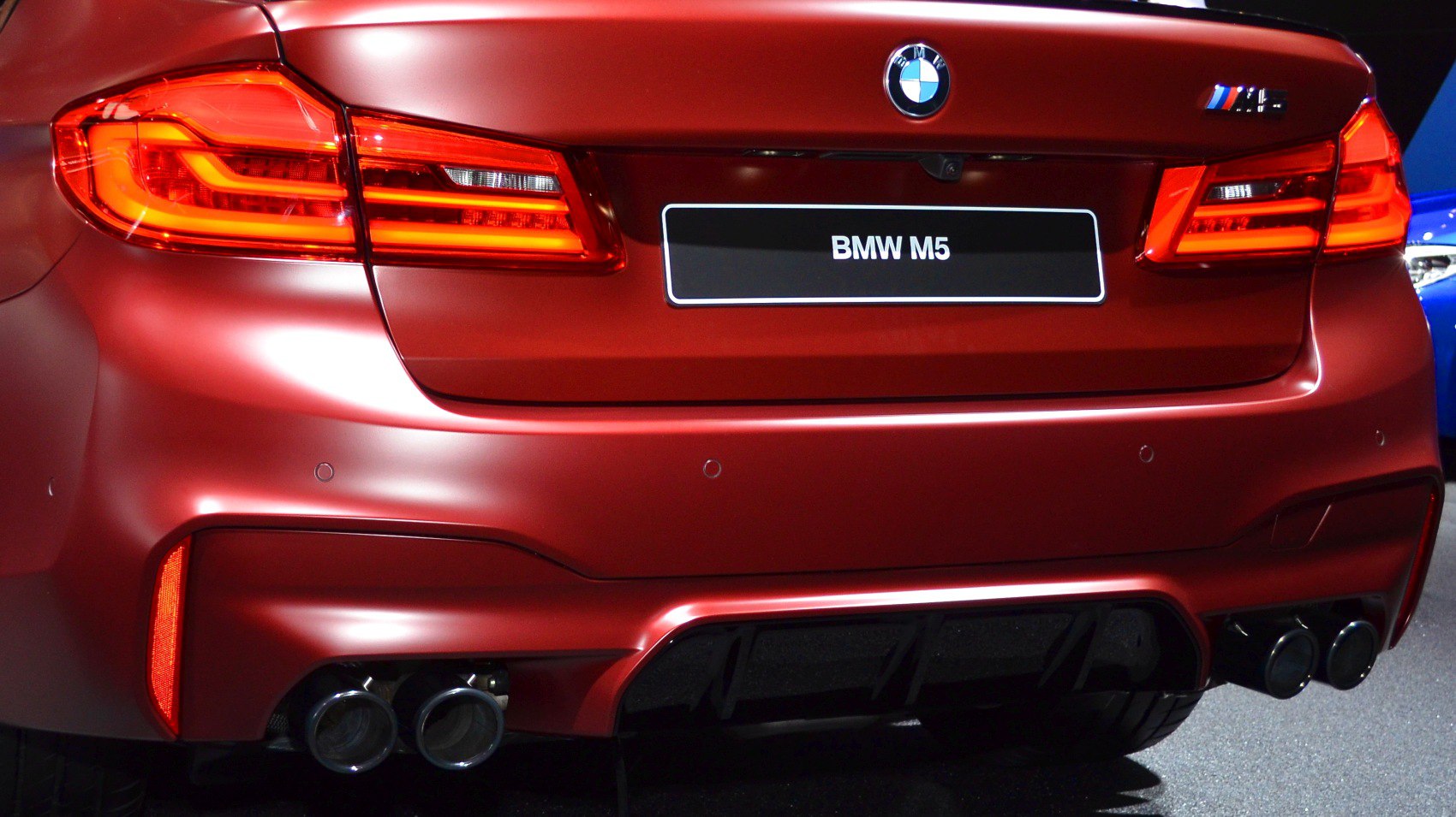 Rear view with illuminated tail lights and quad exhausts