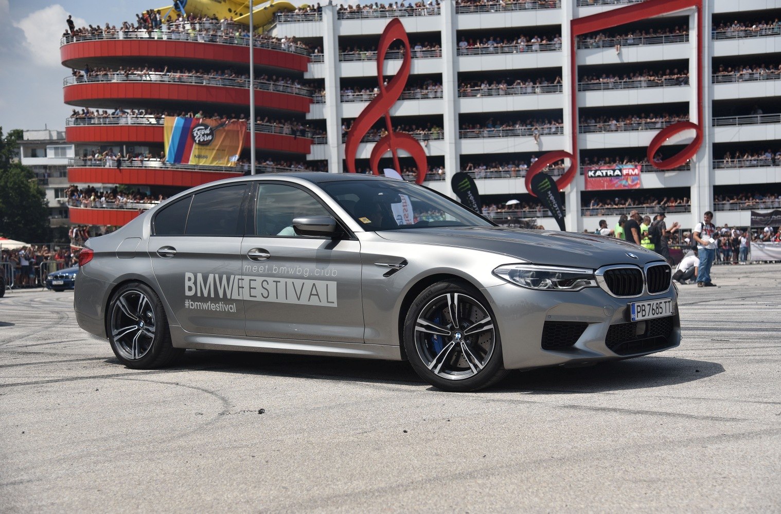 Silver sport sedan with BMW Festival branding at outdoor event