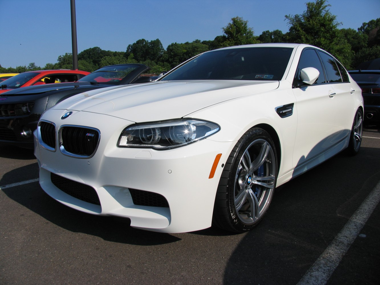 White sports sedan front and side profile with aggressive grille and headlights