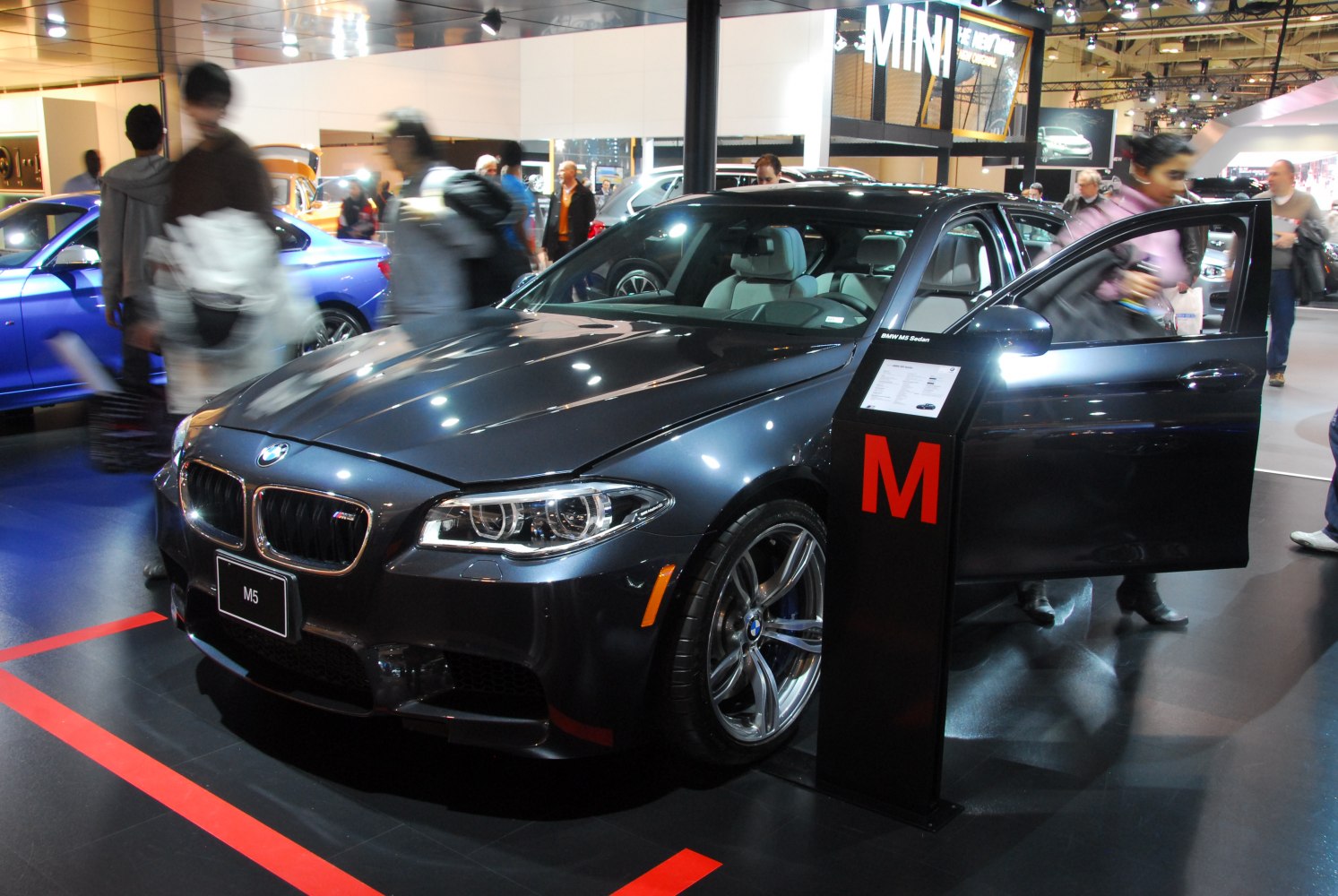 Black luxury sedan front with LED headlights and open door.