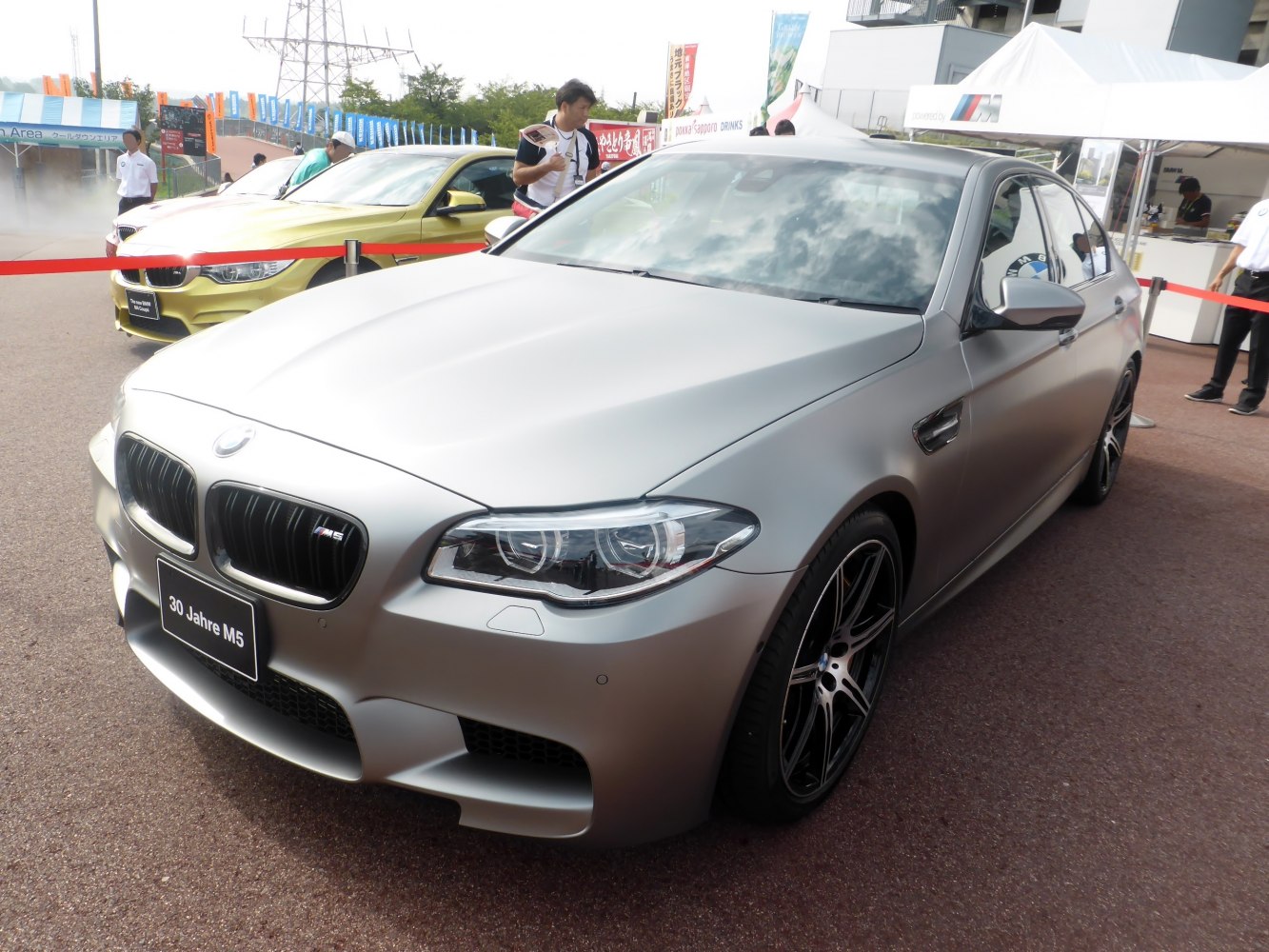 Matte silver luxury sedan front with aggressive headlights and grille