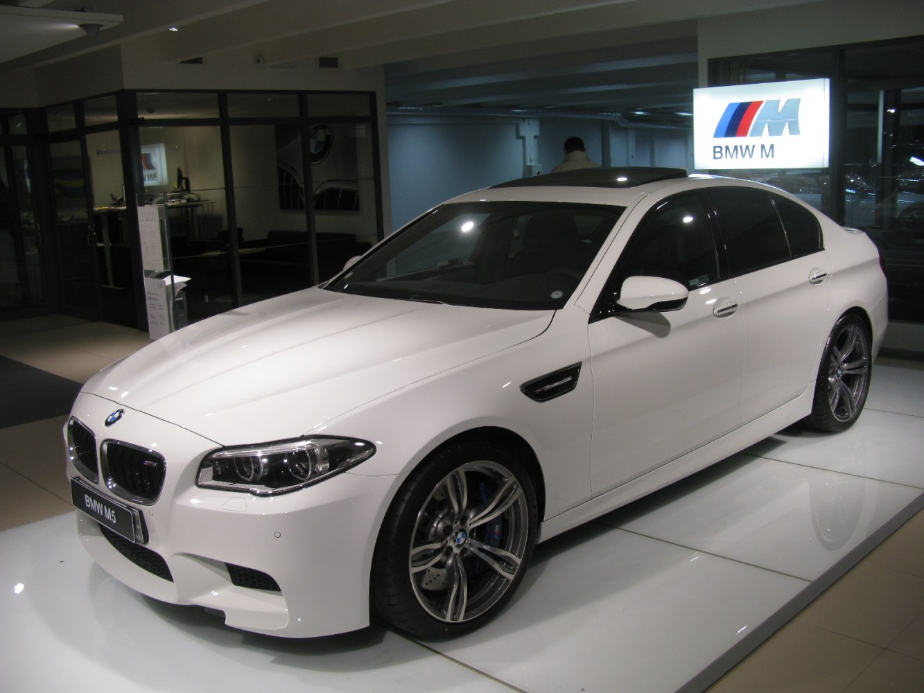 White luxury sedan front side view with distinctive grille and alloy wheels