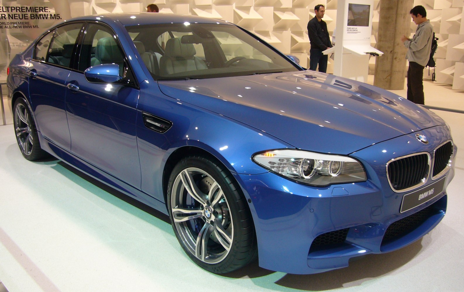 Blue sedan front side with headlights and alloy wheels