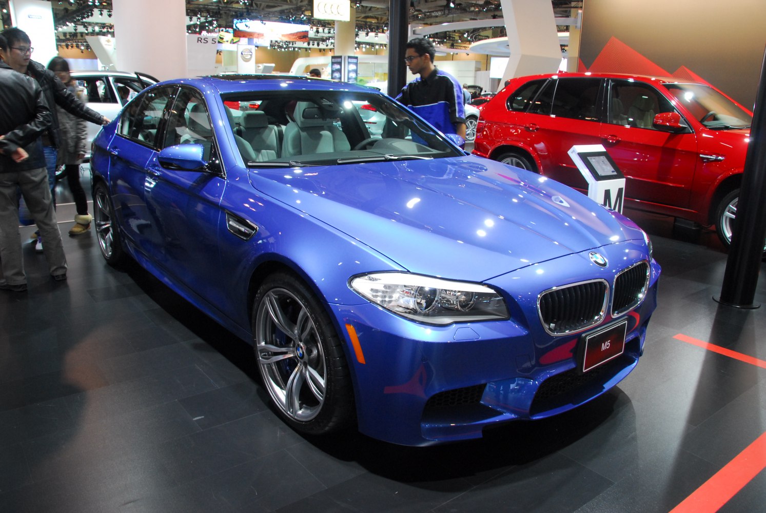 Blue sporty sedan front view with prominent grille and alloy wheels