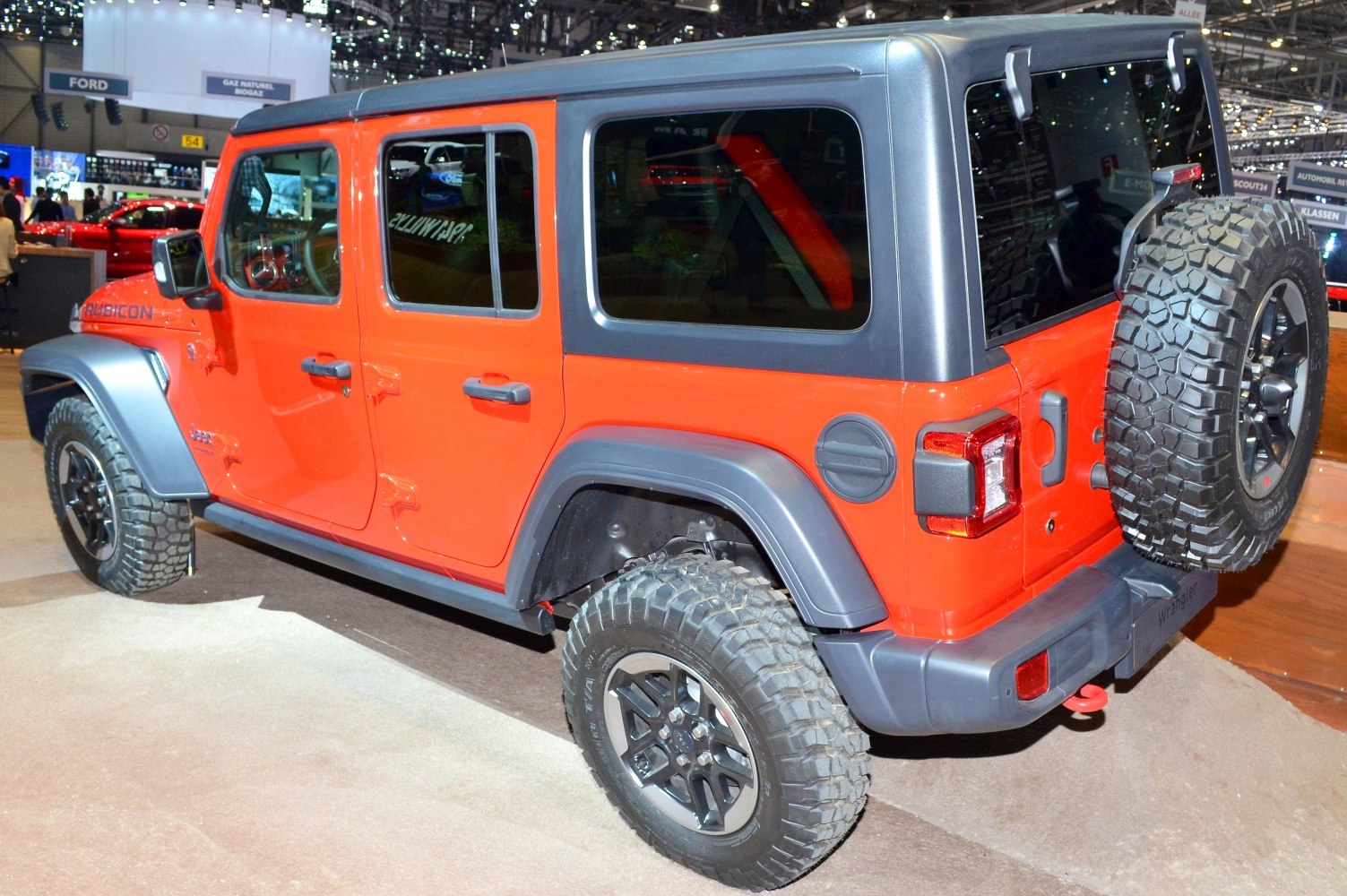 Orange Jeep SUV with rugged off-road tires and boxy rear design