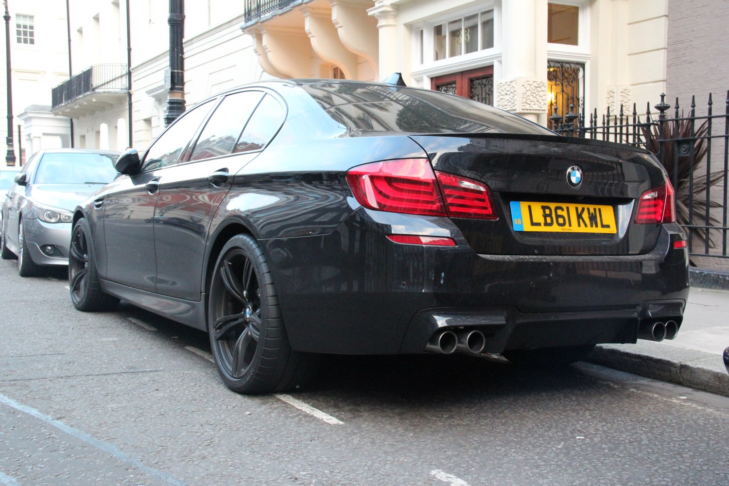 Rear view of sedan with quad exhaust and black sporty wheels