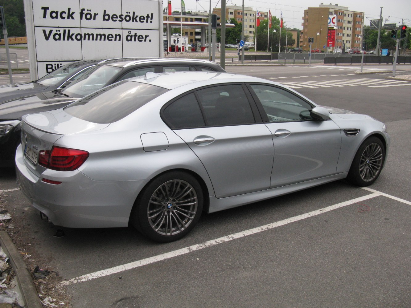 Silver sports sedan rear side view with alloy wheels.