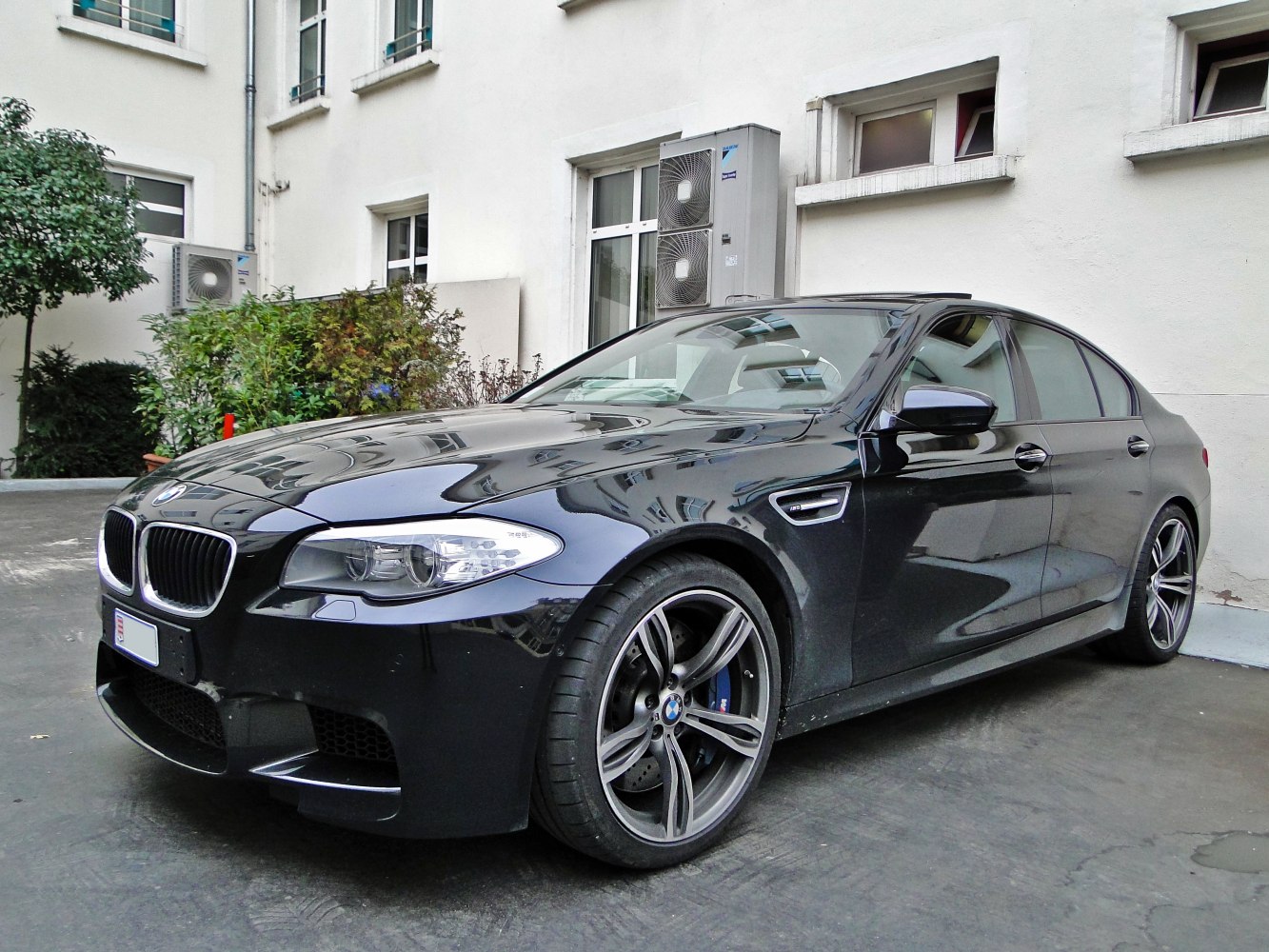 Front-side view of a sporty sedan with alloy wheels.