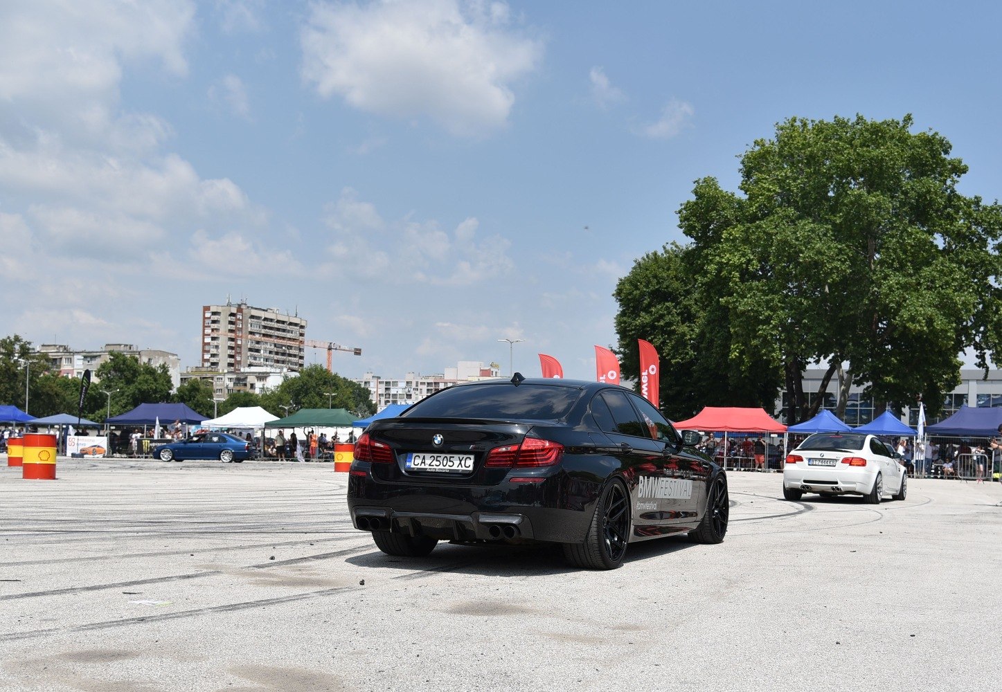 Black sedan with sport tires and quad exhaust at car festival
