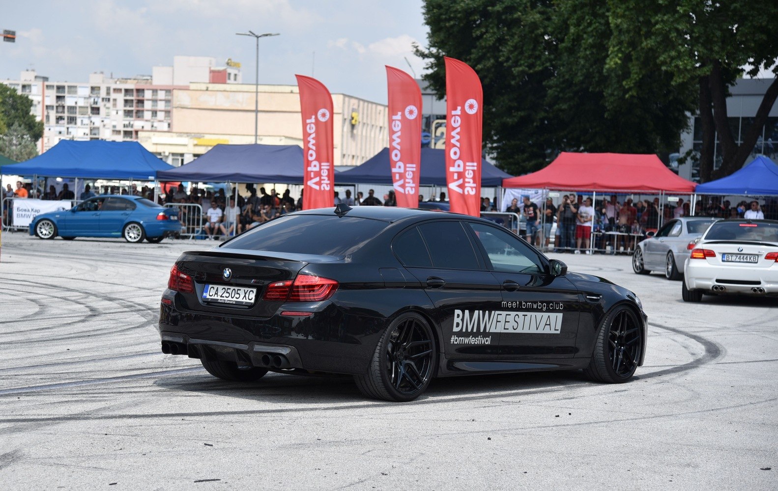 Rear view of BMW M5 with black alloy wheels and quad exhaust tip setup.